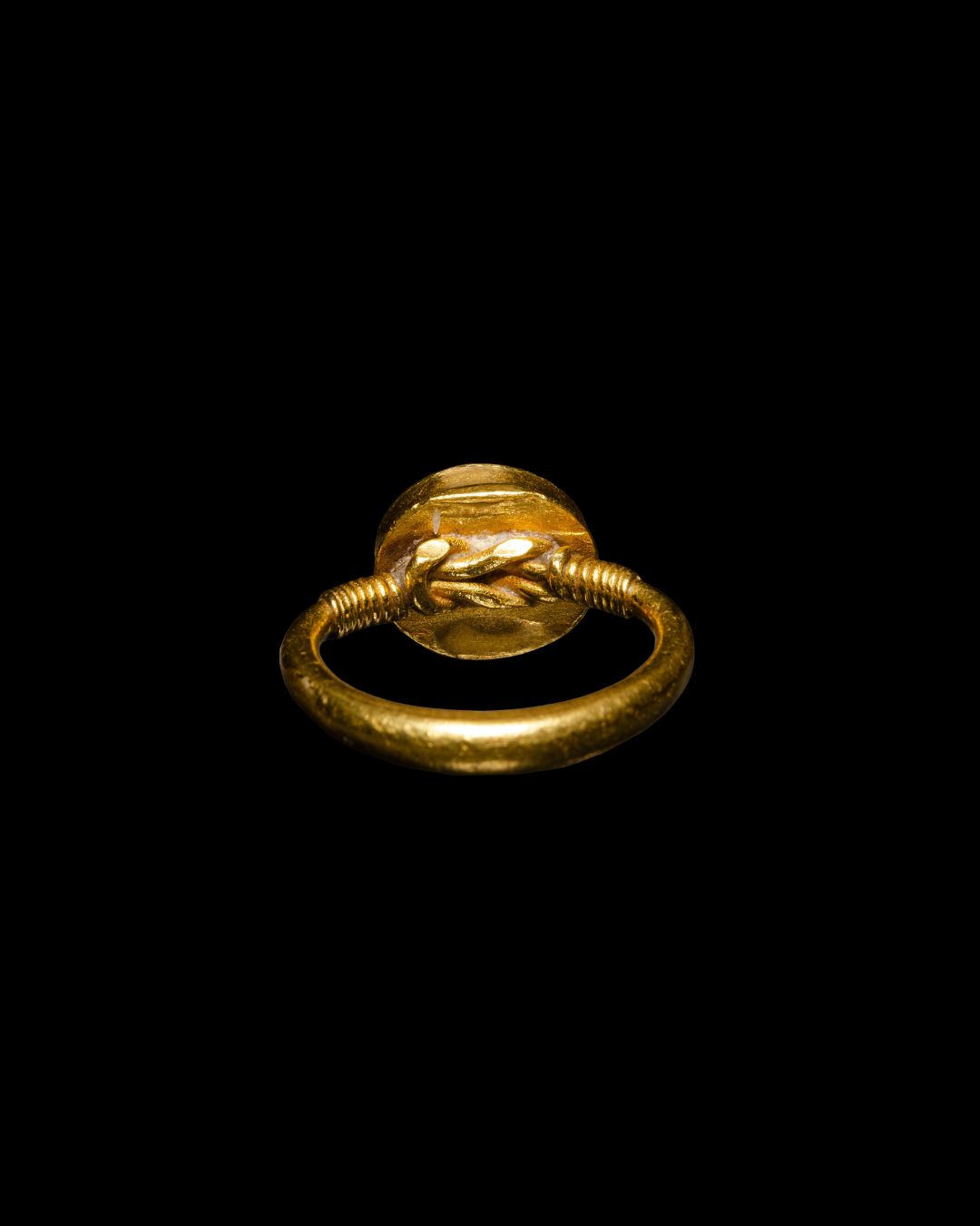 A High-carat gold ring set with a Roman carnelian intaglio of a butterfly on a palm branch
