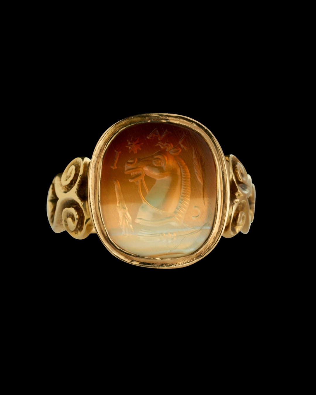 A Victorian gold signet ring set with an agate intaglio. Horse promote with attributes and letters.
