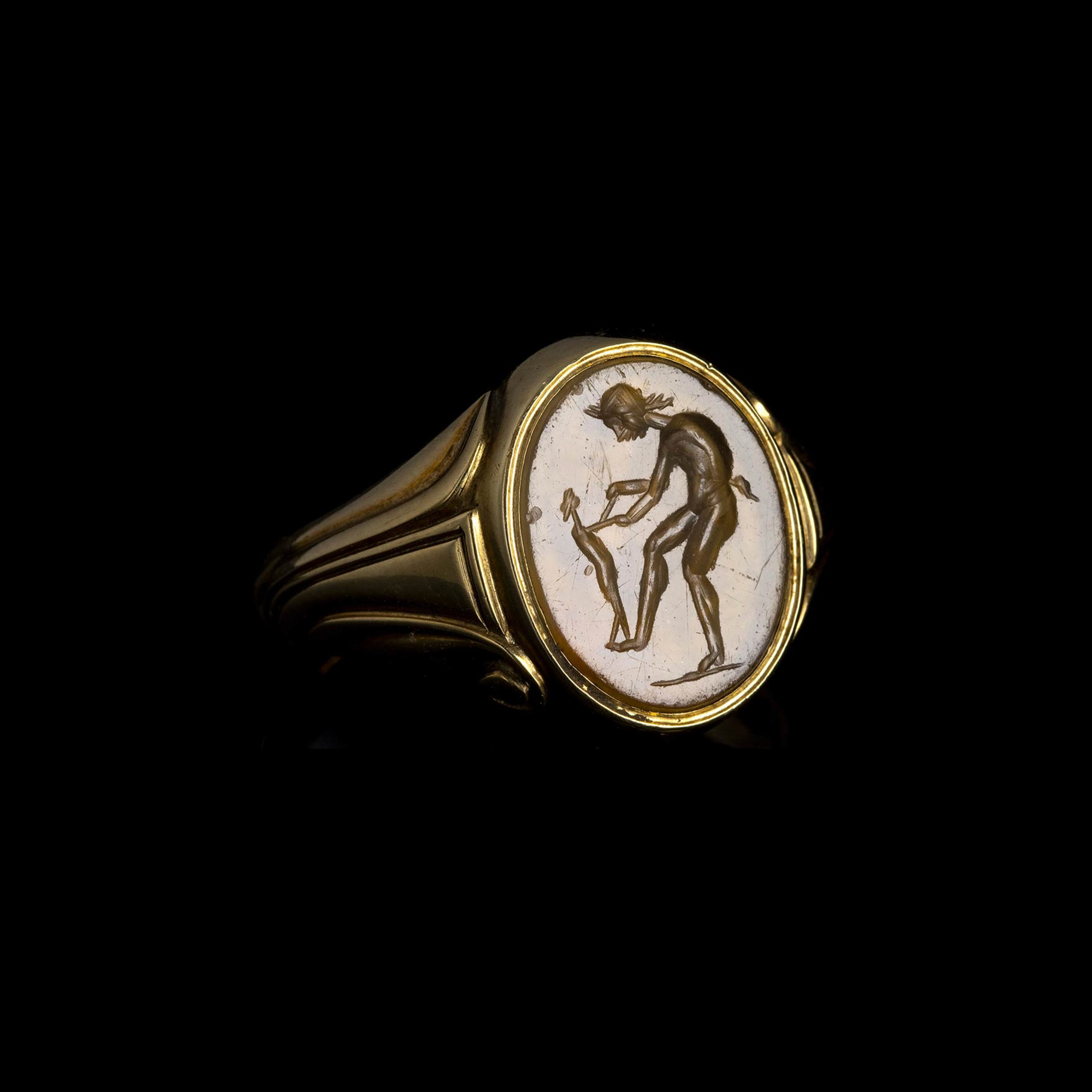 Intaille romaine en calcédoine montée sur une bague en or postérieure. Jeune satyre dansant avec un enfant.