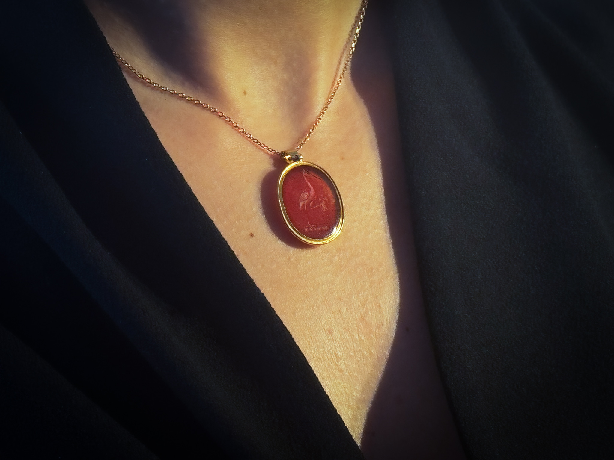 Neoclassical, A gold pendant set with a Neoclassical carnelian intaglio. Allegorical scene with a crane. (Early 19th century)