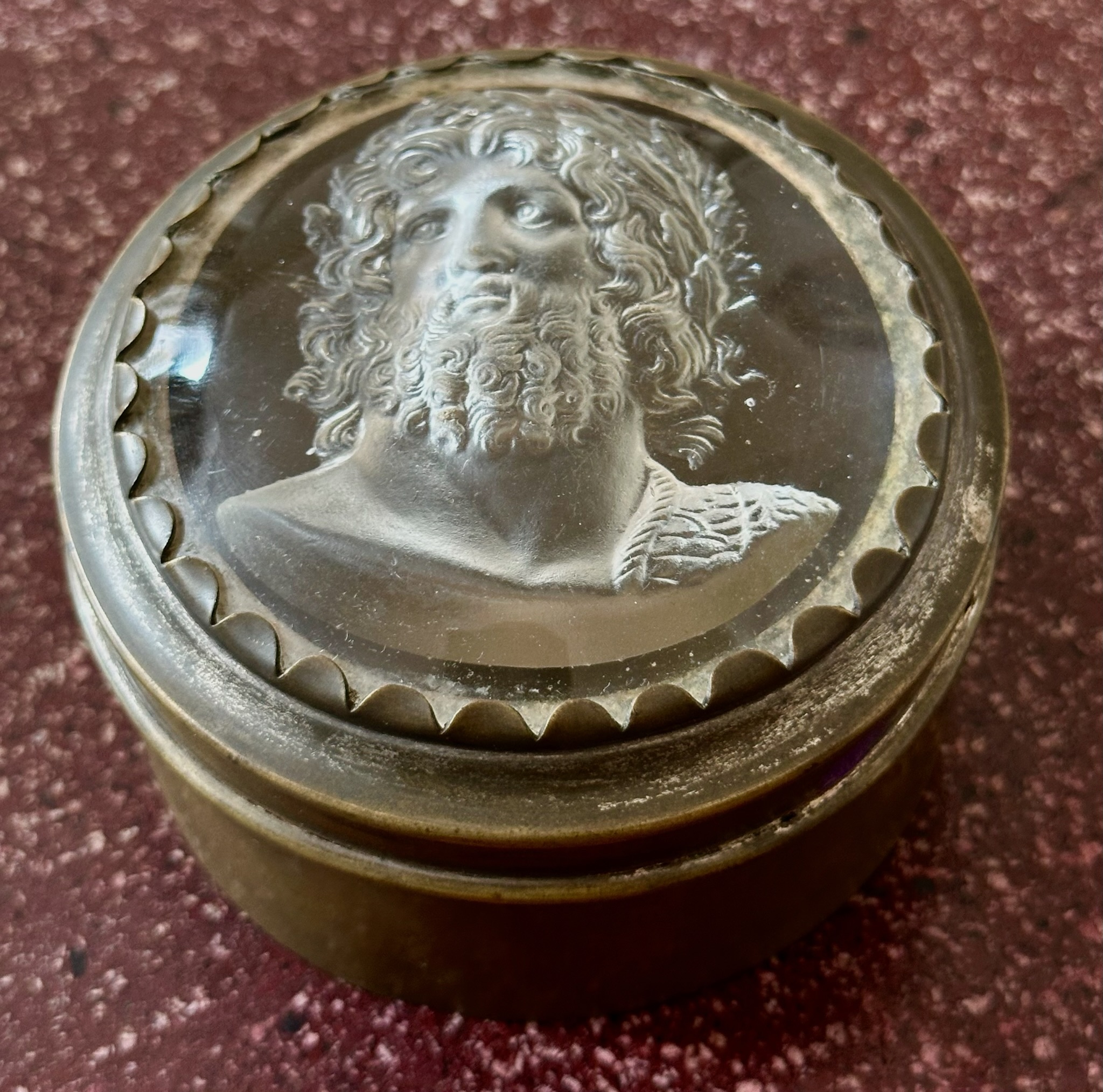 An early 19th-century silvered brass snuff box, the lid set with a large glass paste of Jupiter Aegiochus after the Zulian intaglio.
