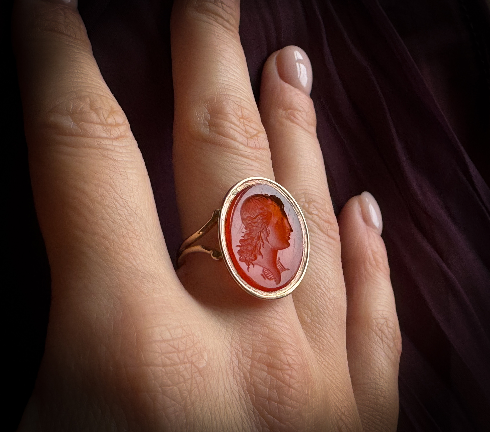 Neoclassical, A 19th century gold ring set with a Neoclassical carnelian intaglio. Bust of Apollo.  (19th century)