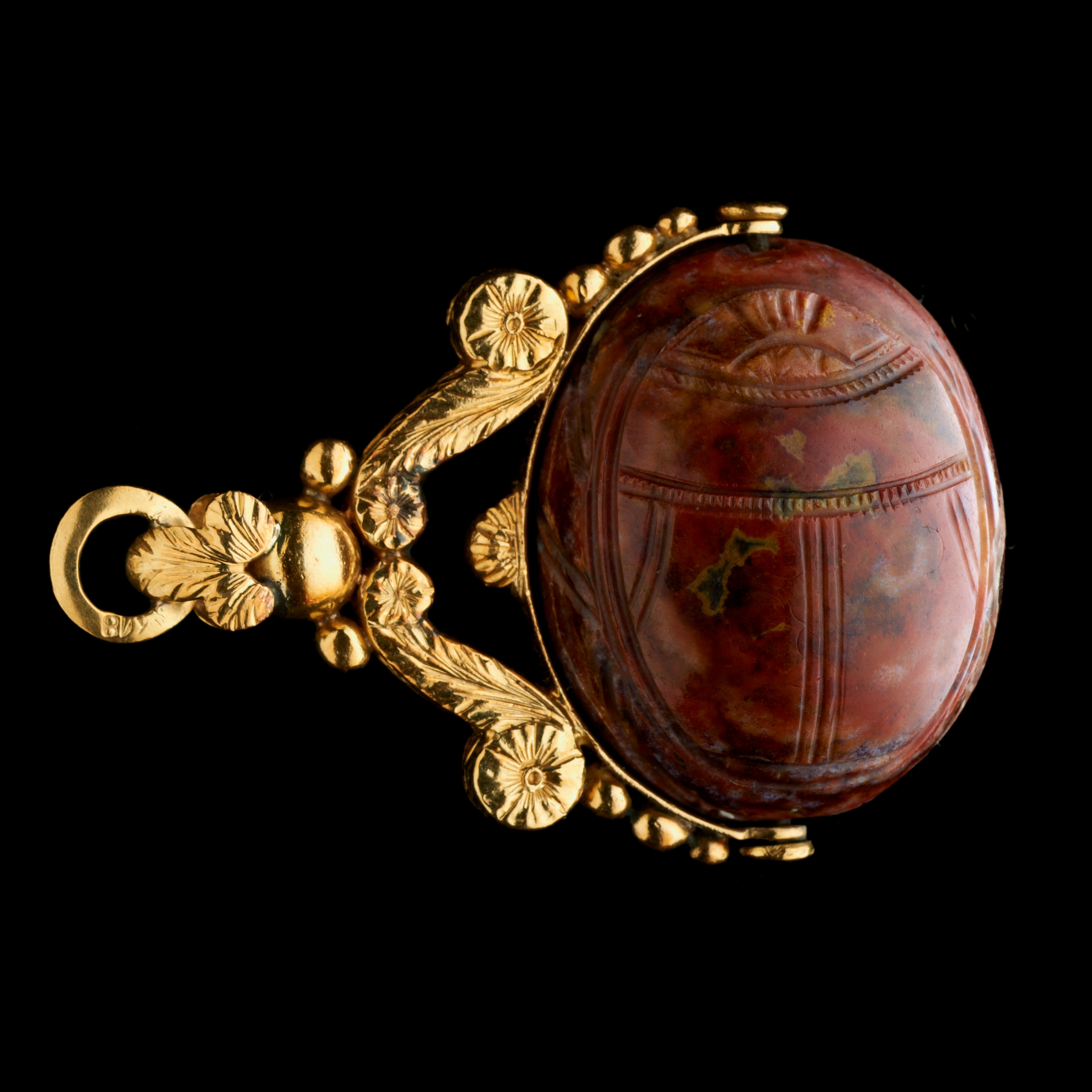 A late 18th c. gold swivel chiseled seal pendant set with a large red jasper engraved scarab. Jupiter.