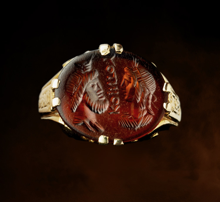 A Late 19th - early 20th c. gold chiseled ring set with a Roman Sard intaglio. Isis and Serapis with inscription.