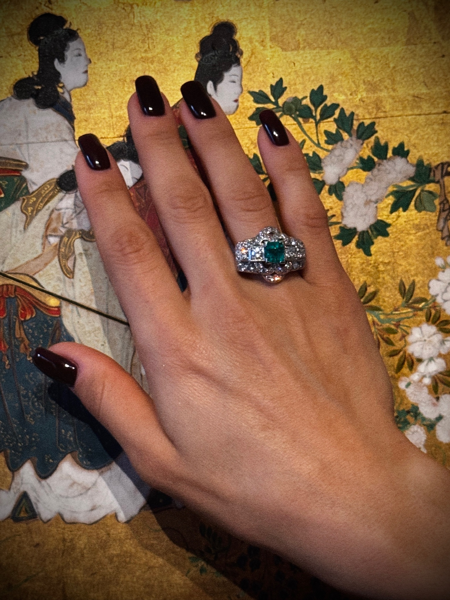 A diamond and platinum ring, set with a rectangular shaped emerald (ca. 1960)