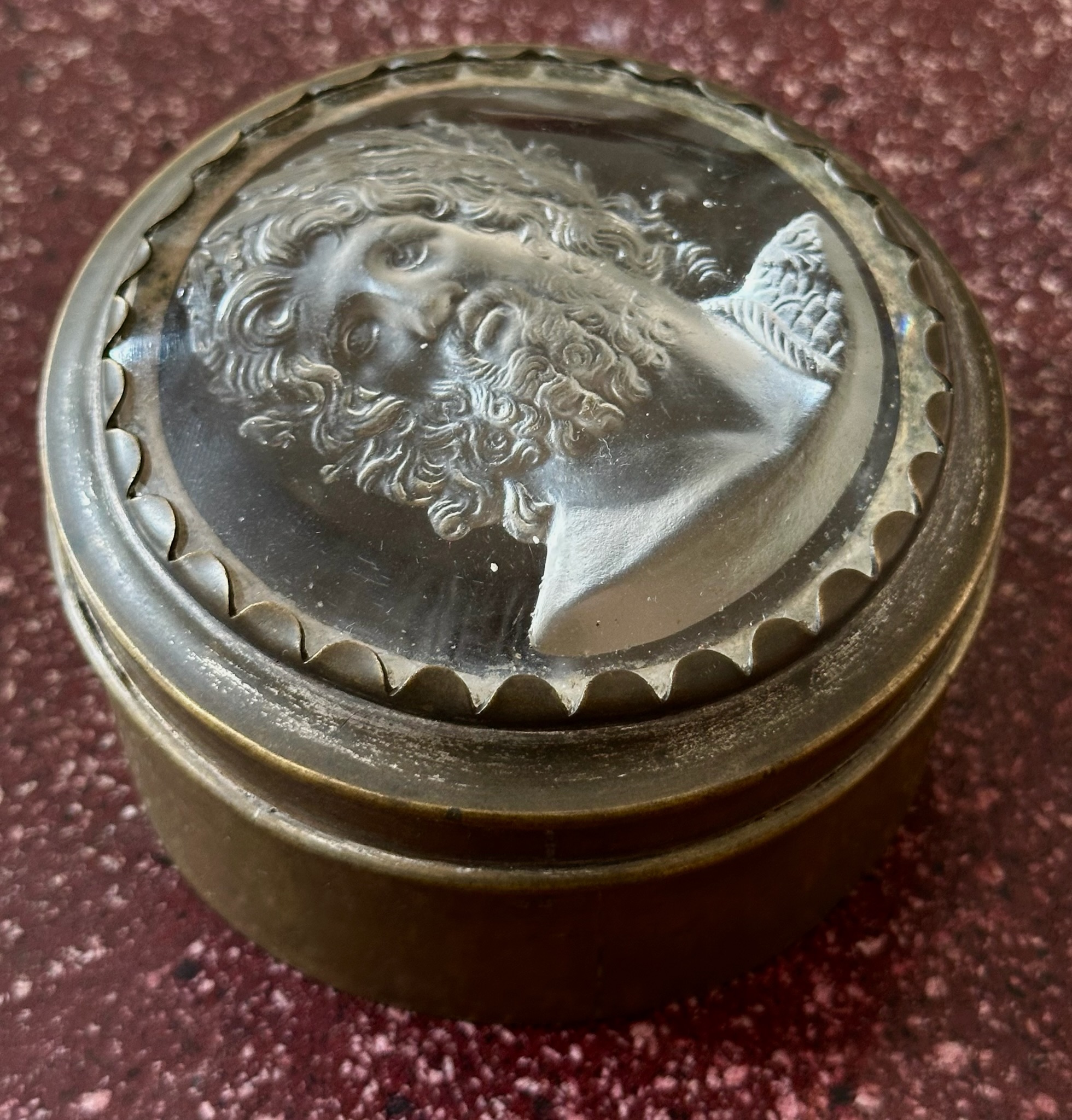 An early 19th-century silvered brass snuff box, the lid set with a large glass paste of Jupiter Aegiochus after the Zulian intaglio.