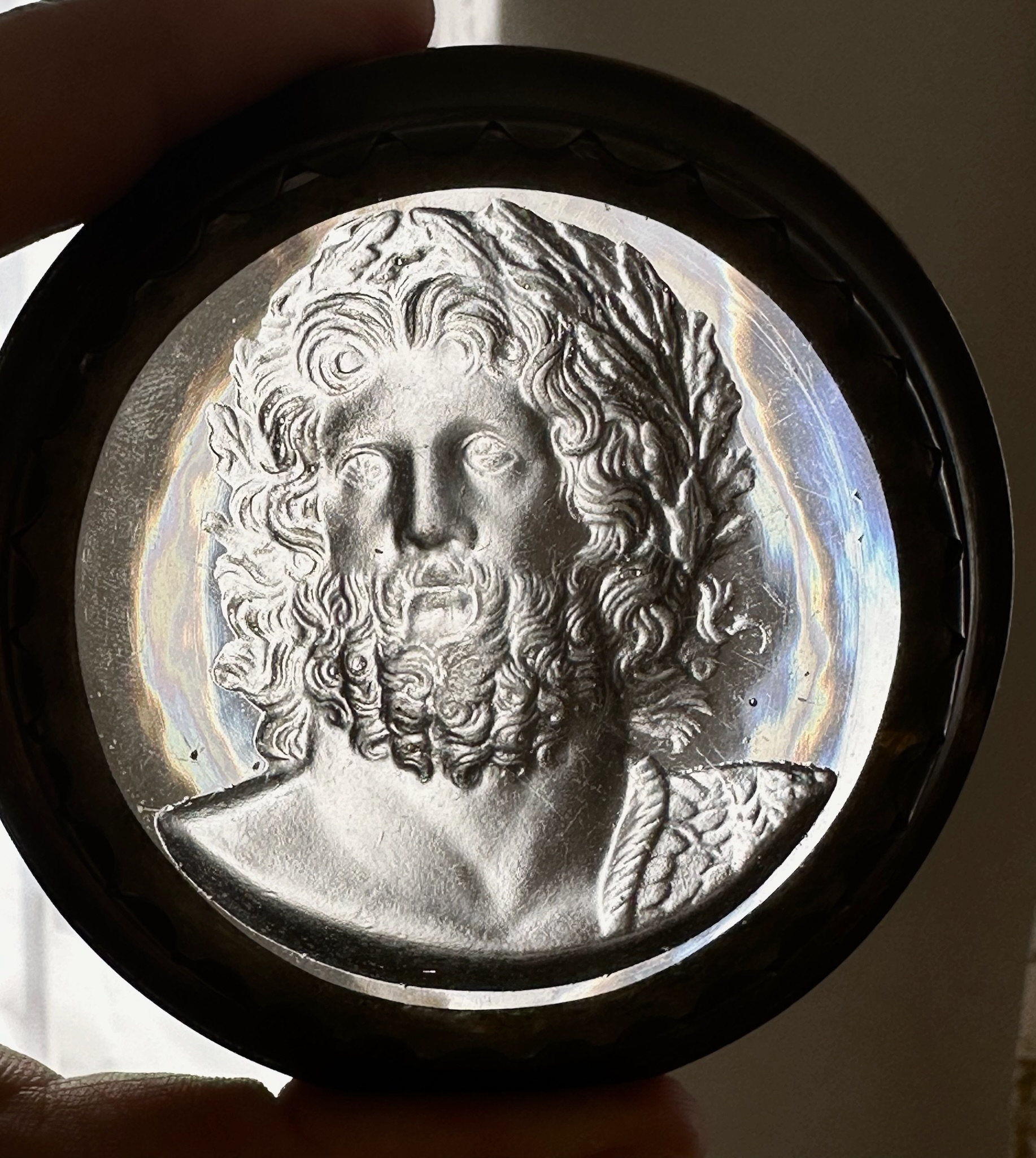 An early 19th-century silvered brass snuff box, the lid set with a large glass paste of Jupiter Aegiochus after the Zulian intaglio.