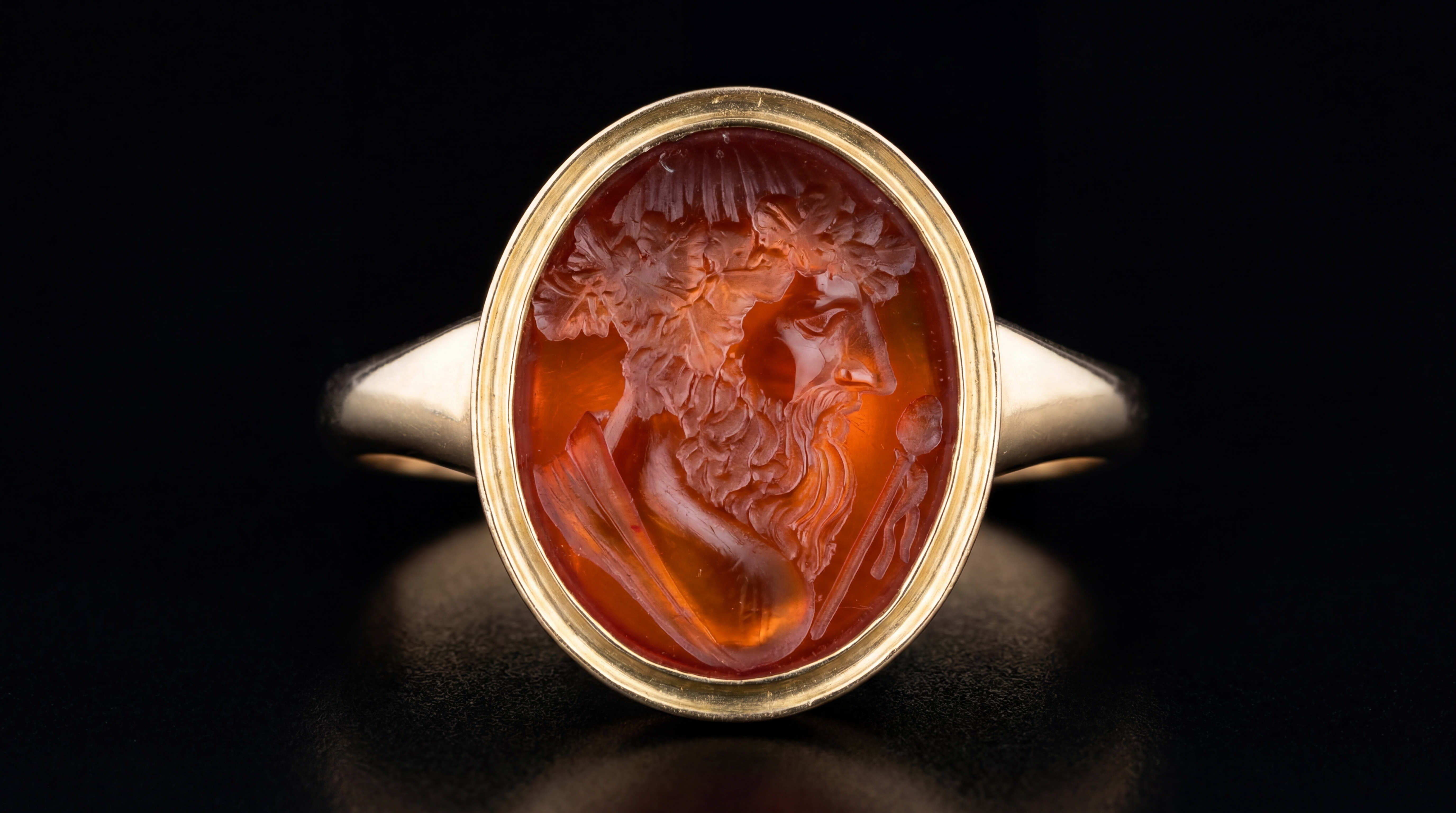 A gold ring set with a carnelian intaglio depicting the bust of Bacchus