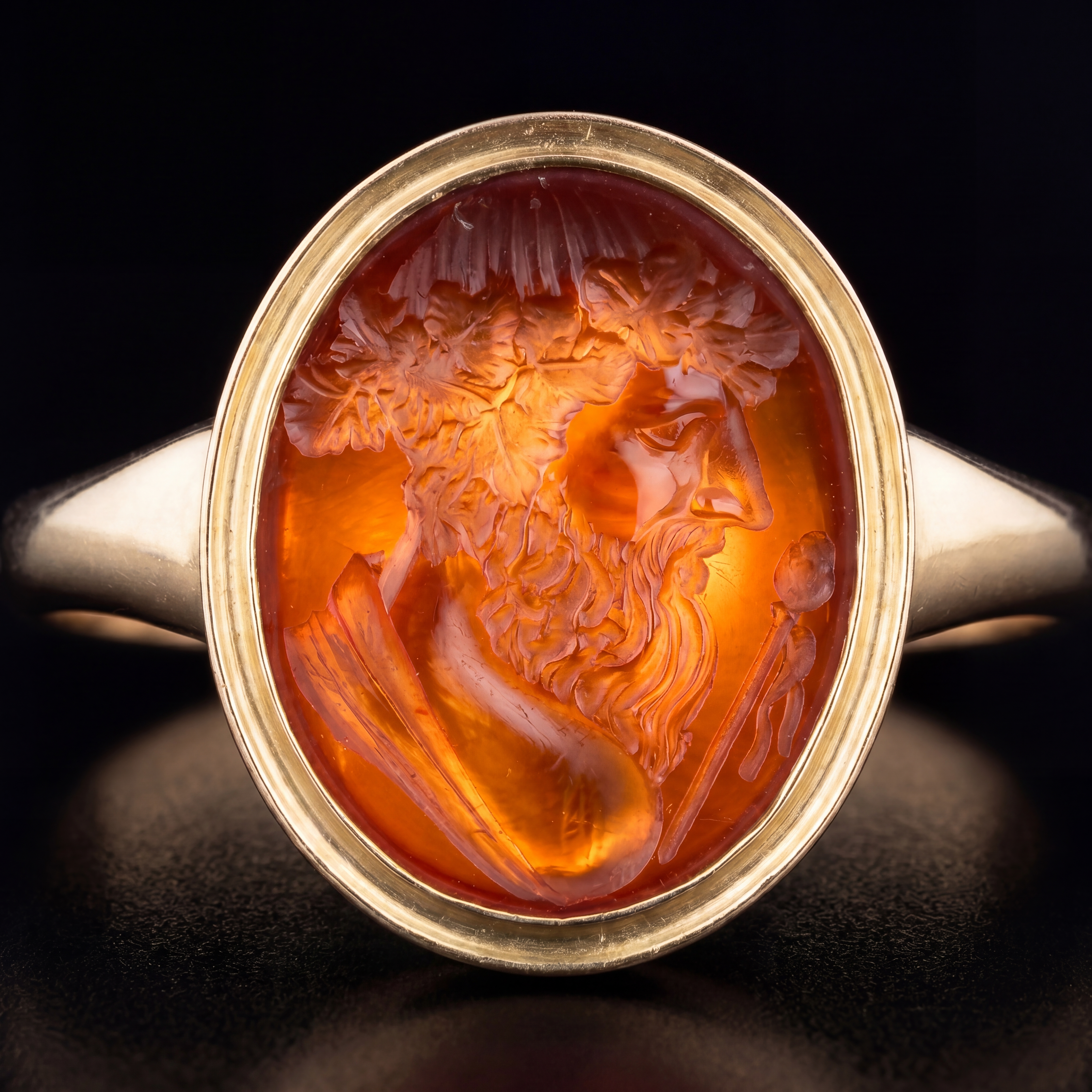 A gold ring set with a carnelian intaglio depicting the bust of Bacchus