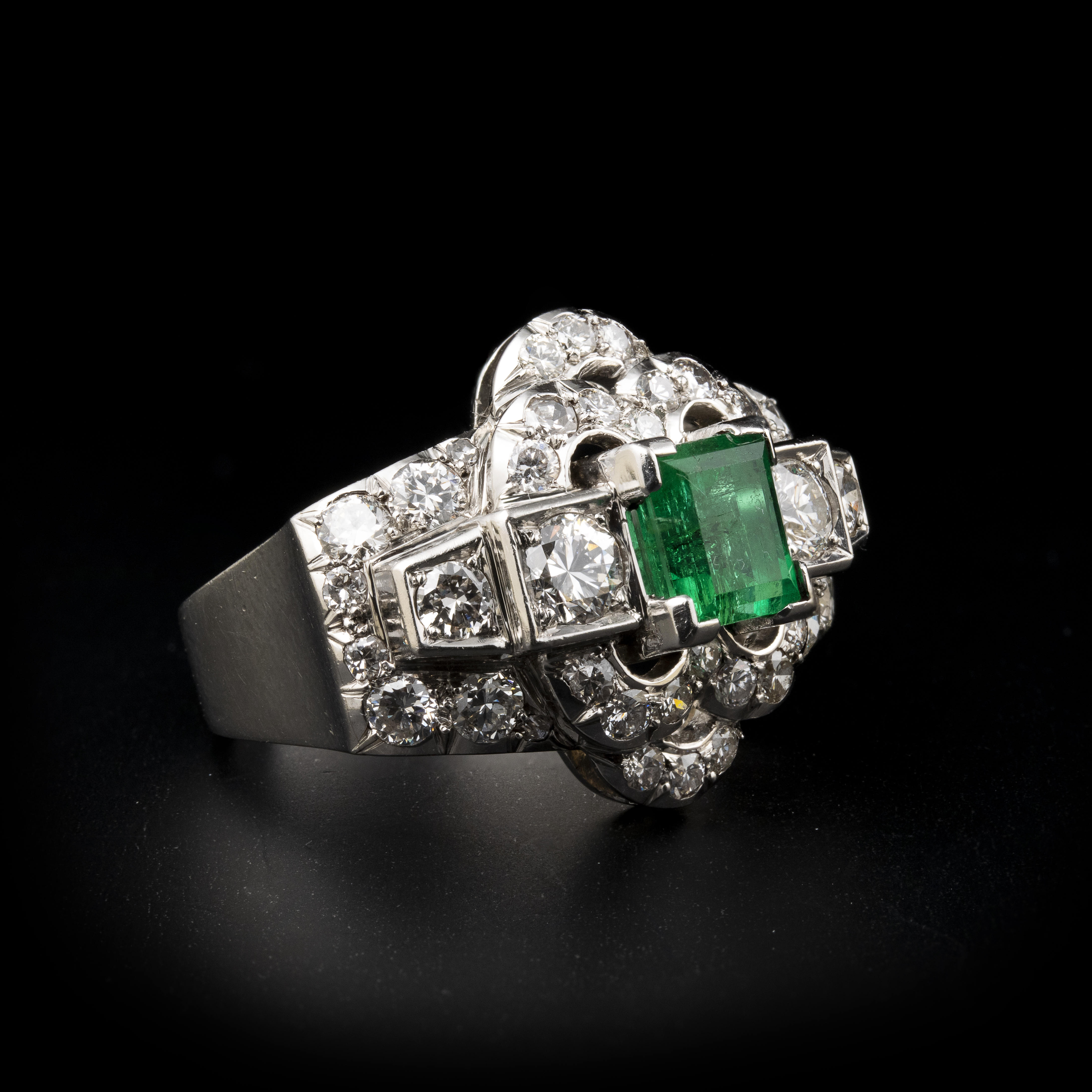 A diamond and platinum ring, set with a rectangular shaped emerald (ca. 1960)