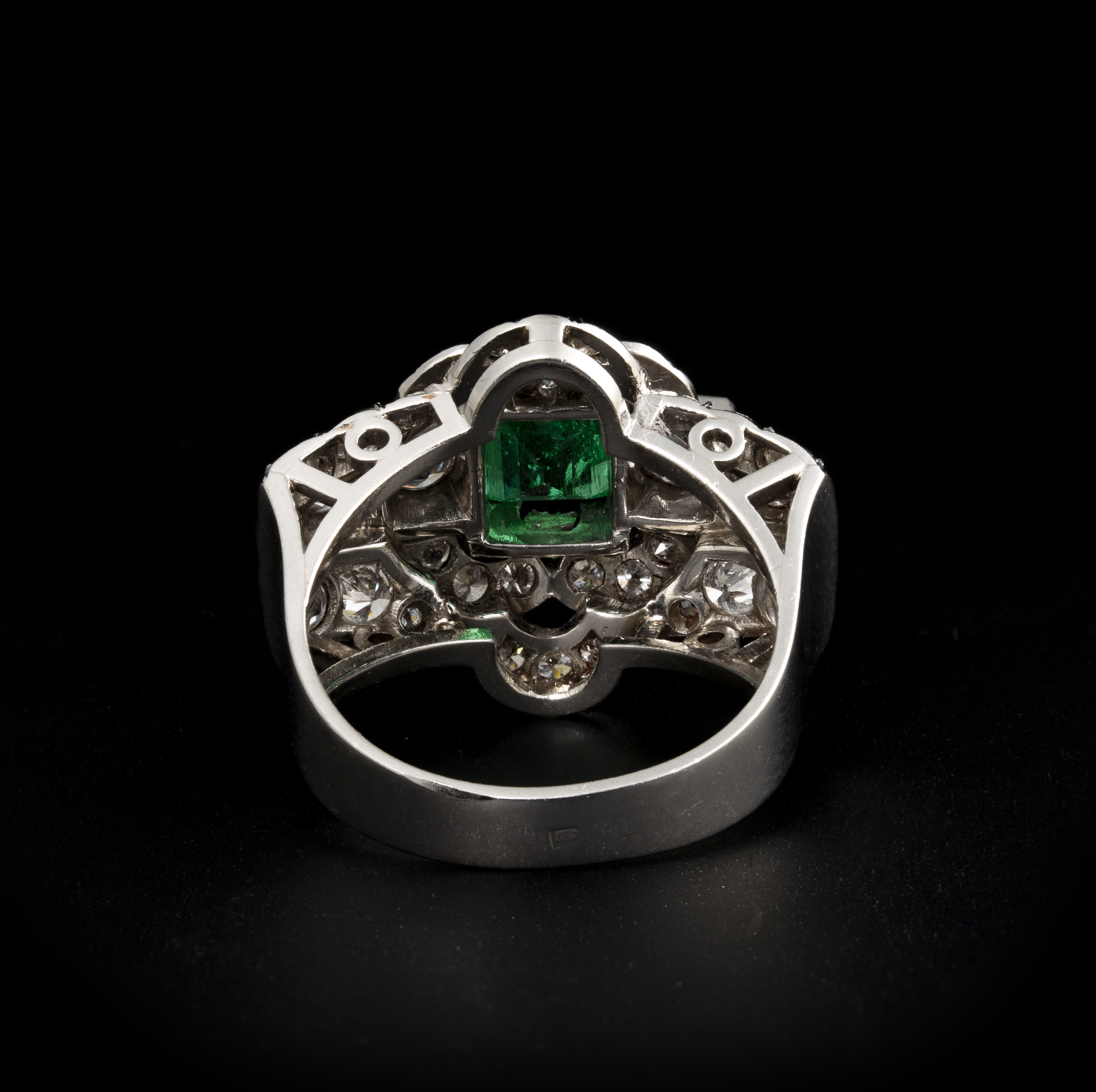 A diamond and platinum ring, set with a rectangular shaped emerald (ca. 1960)
