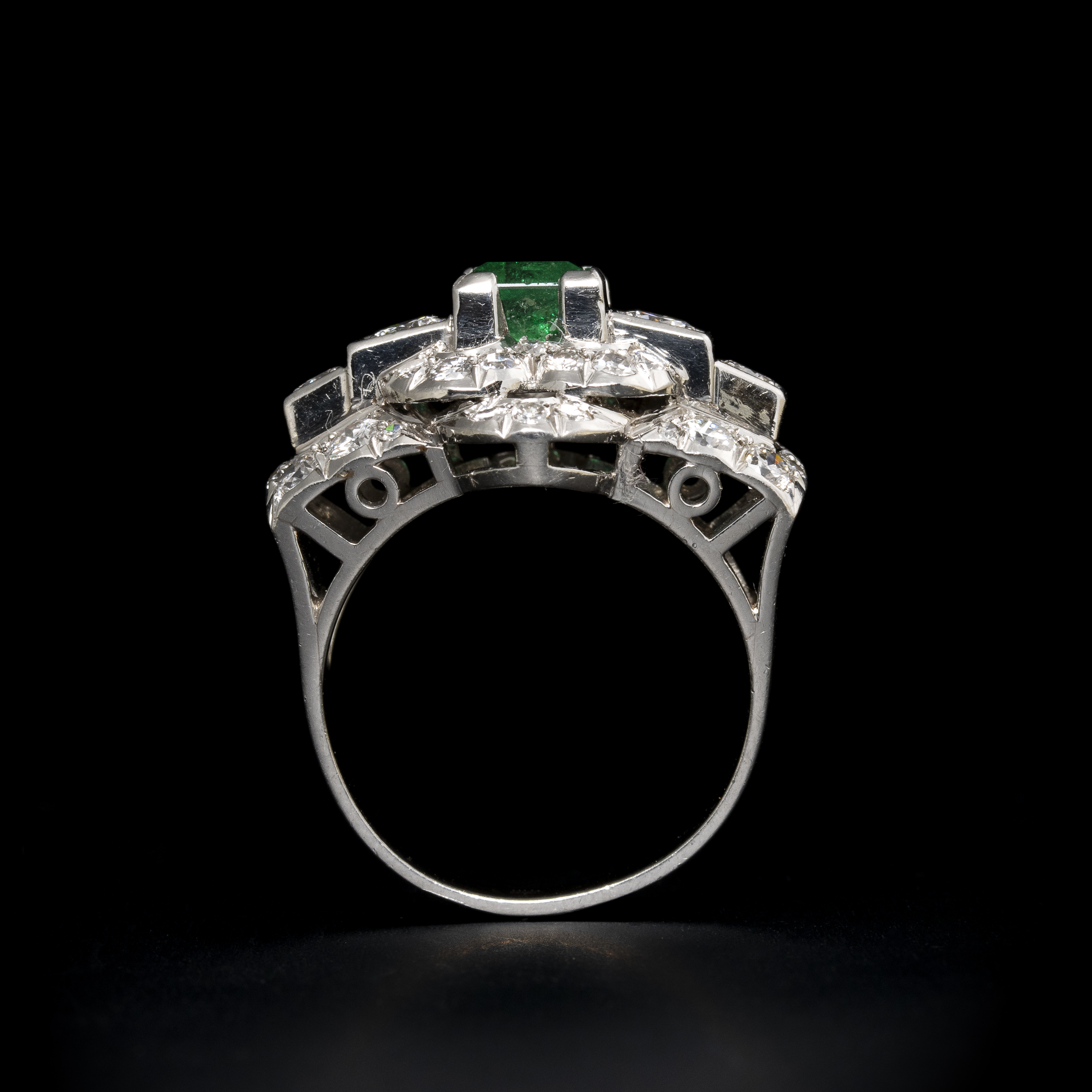 A diamond and platinum ring, set with a rectangular shaped emerald (ca. 1960)