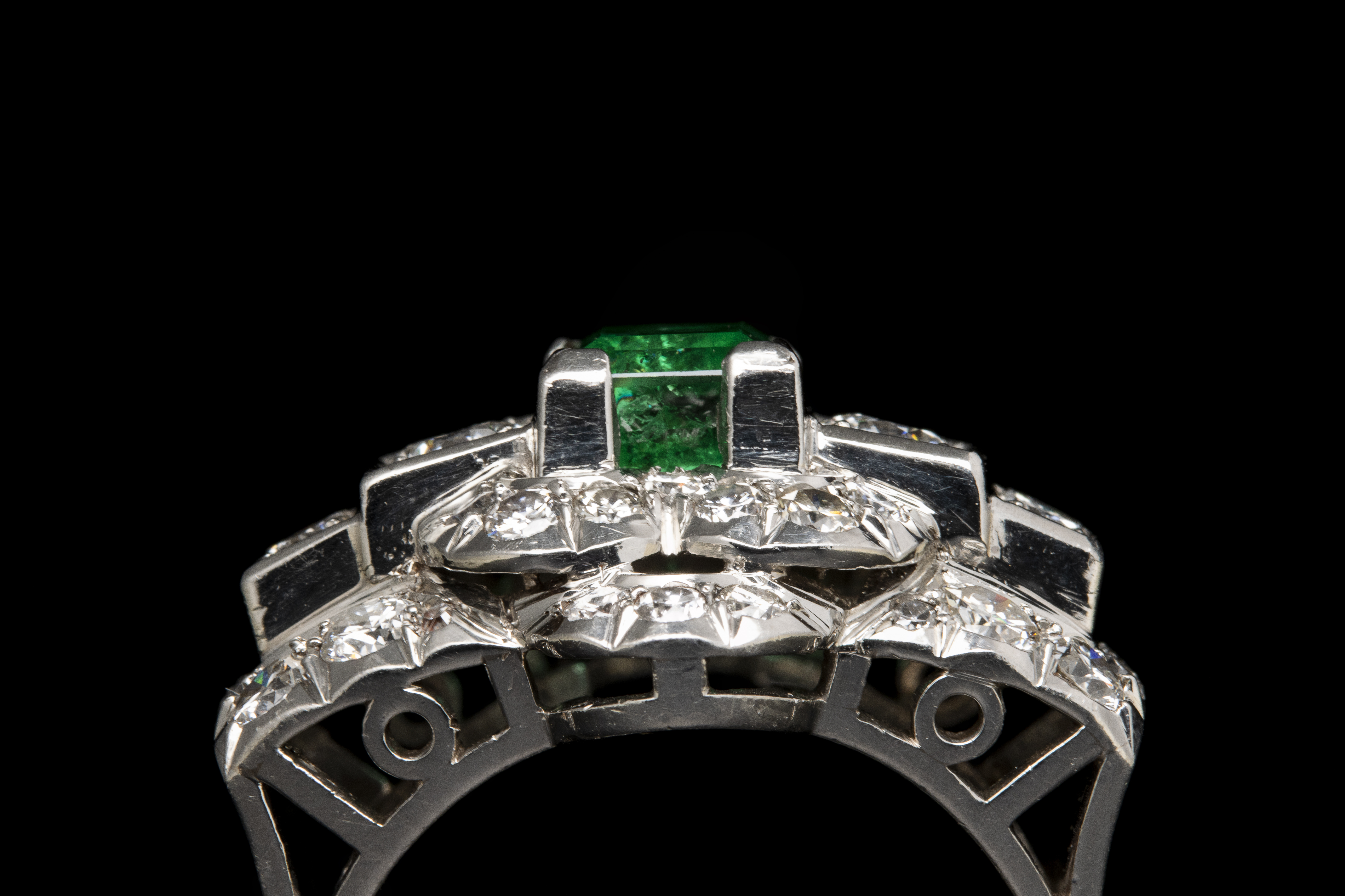 A diamond and platinum ring, set with a rectangular shaped emerald (ca. 1960)