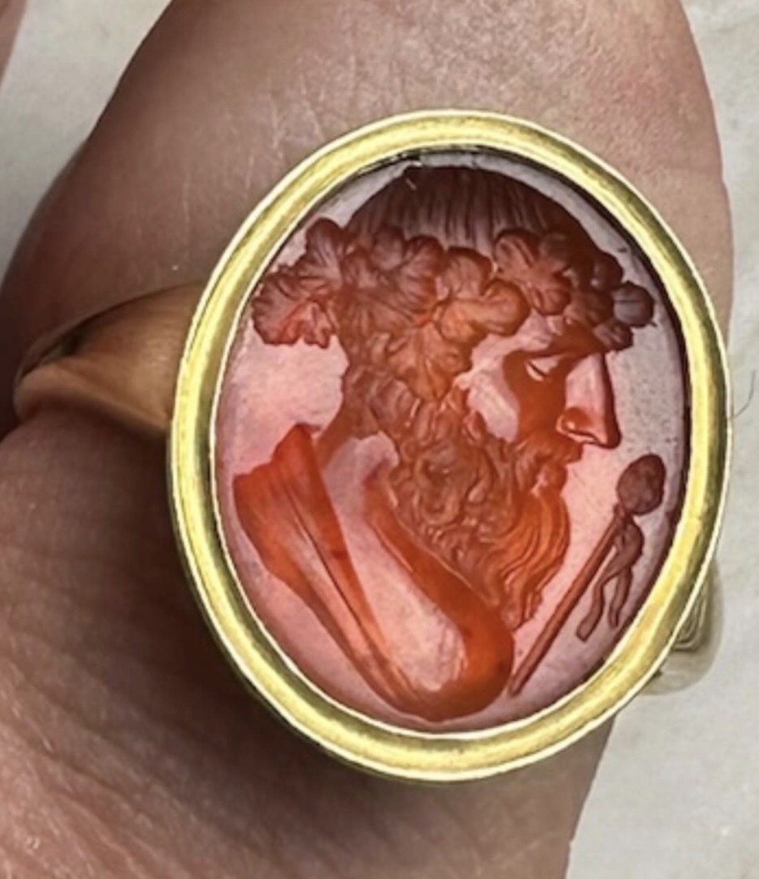 A gold ring set with a carnelian intaglio depicting the bust of Bacchus