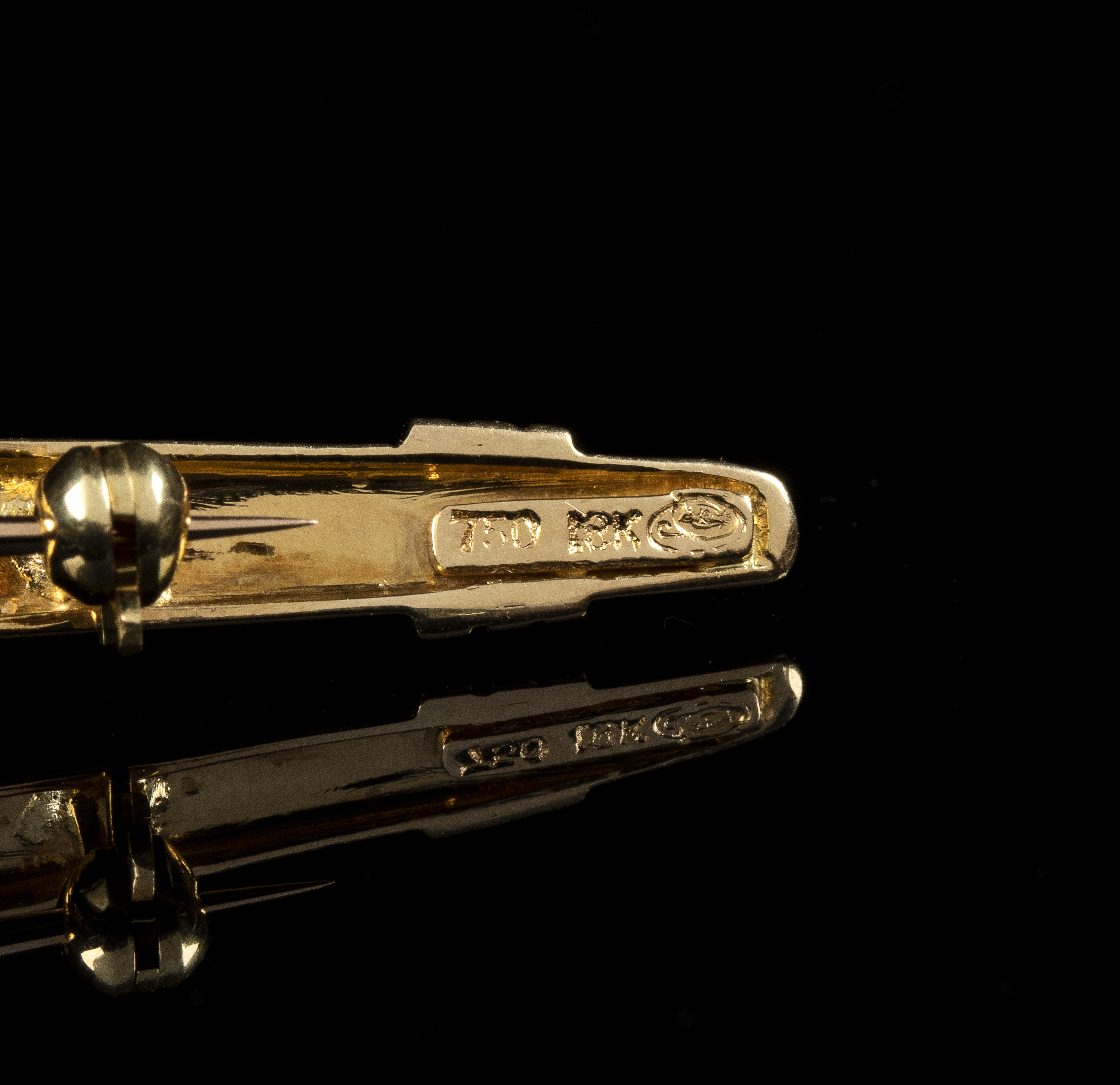 A 18k rose gold bar brooch with pink sapphire