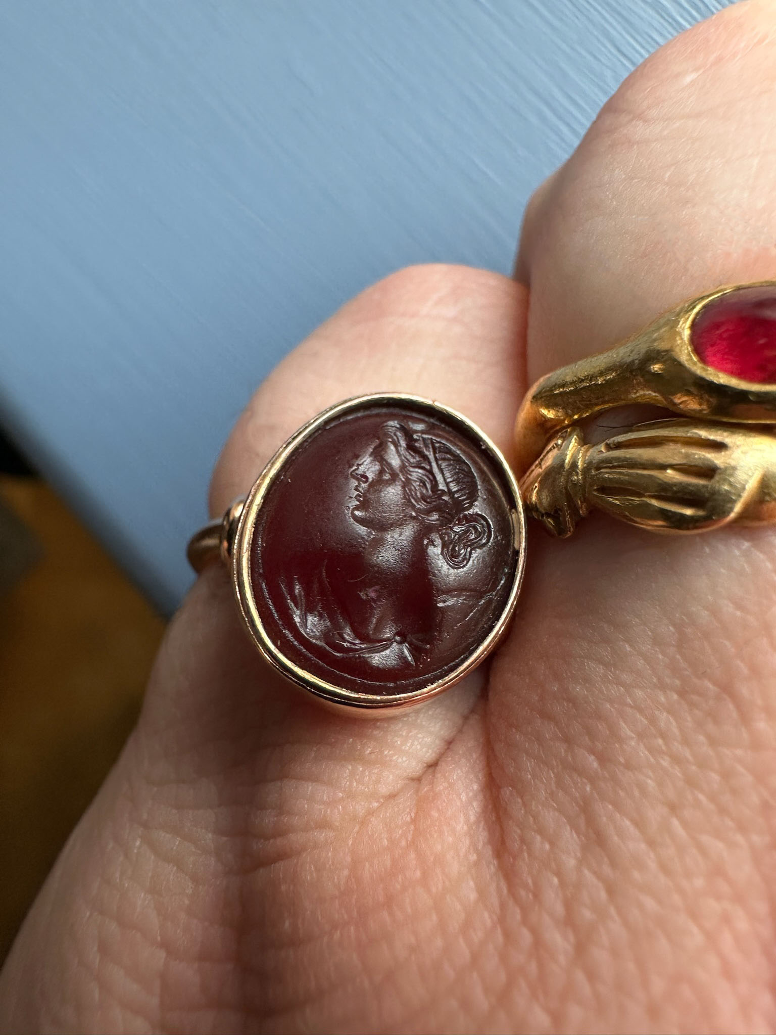 A gold ring set with a 19th century red glass intaglio. Bust of Diana.