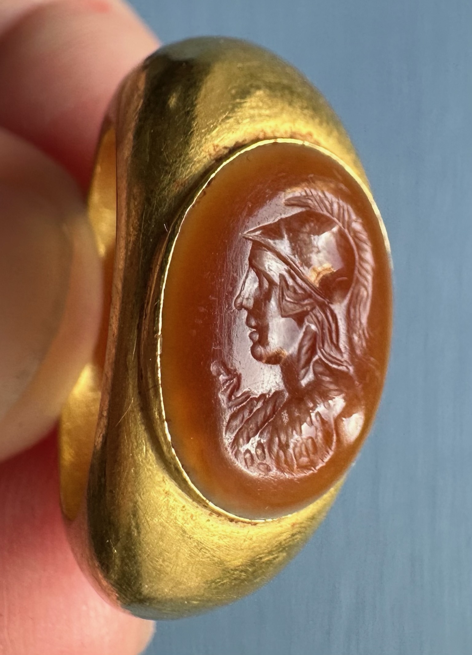 A large Roman hollow gold ring set with an agate intaglio. Bust of Athena.