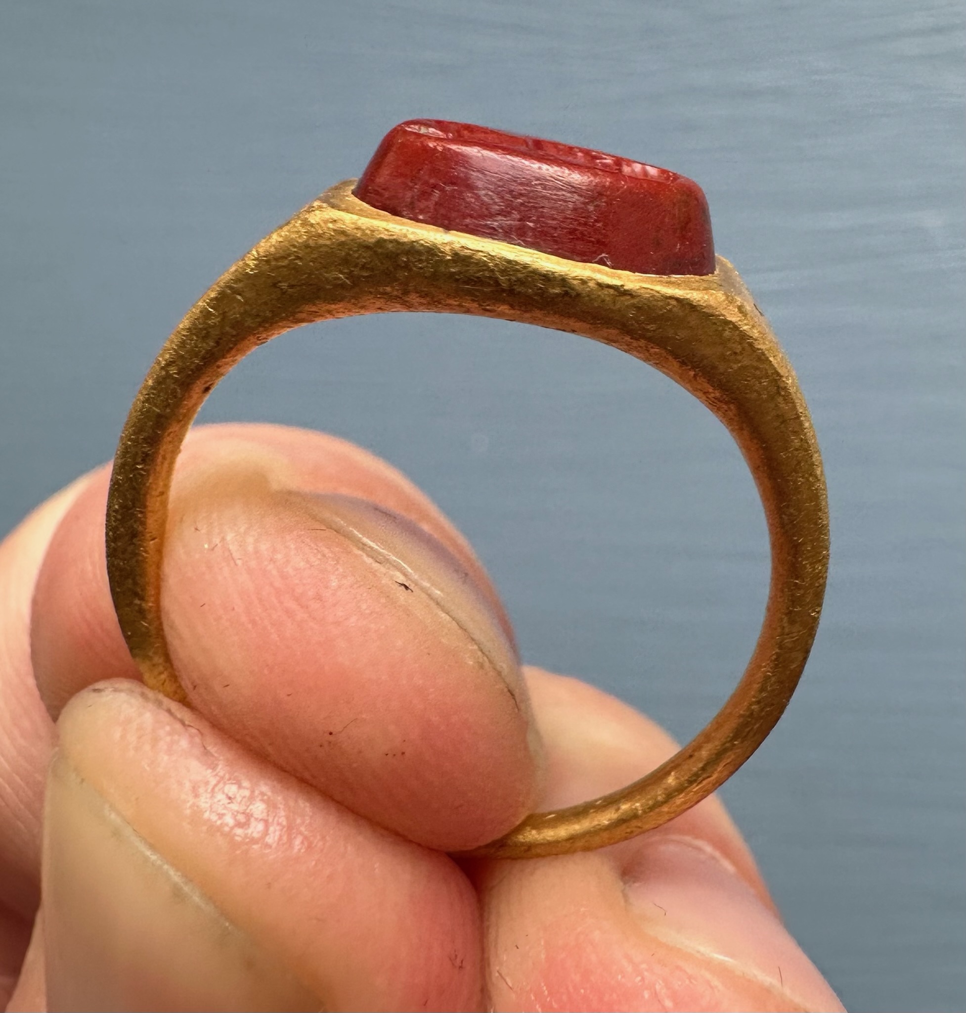 A Roman gold ring set with a red jasper intaglio. Bust of Mercury. 