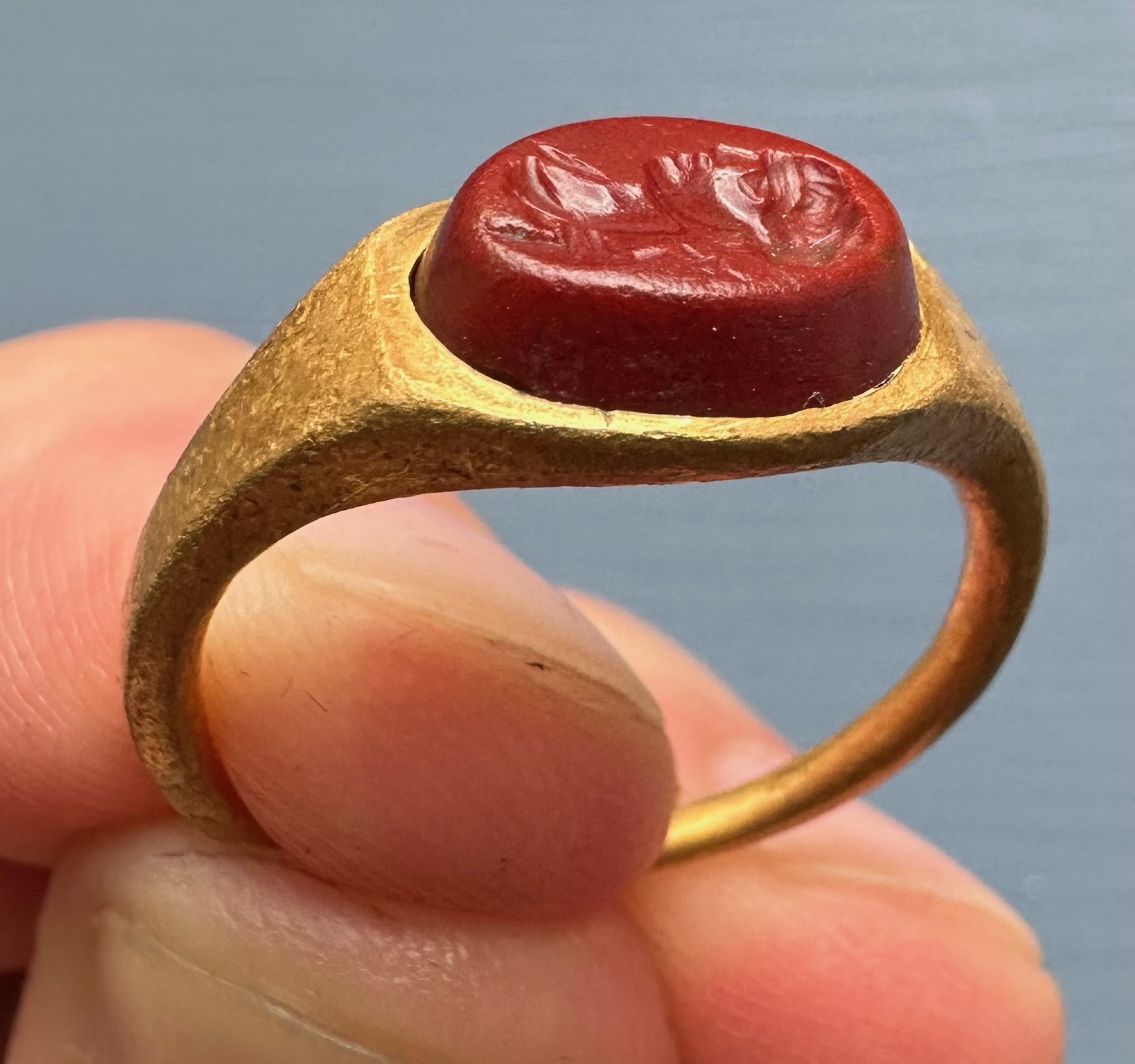 A Roman gold ring set with a red jasper intaglio. Bust of Mercury. 