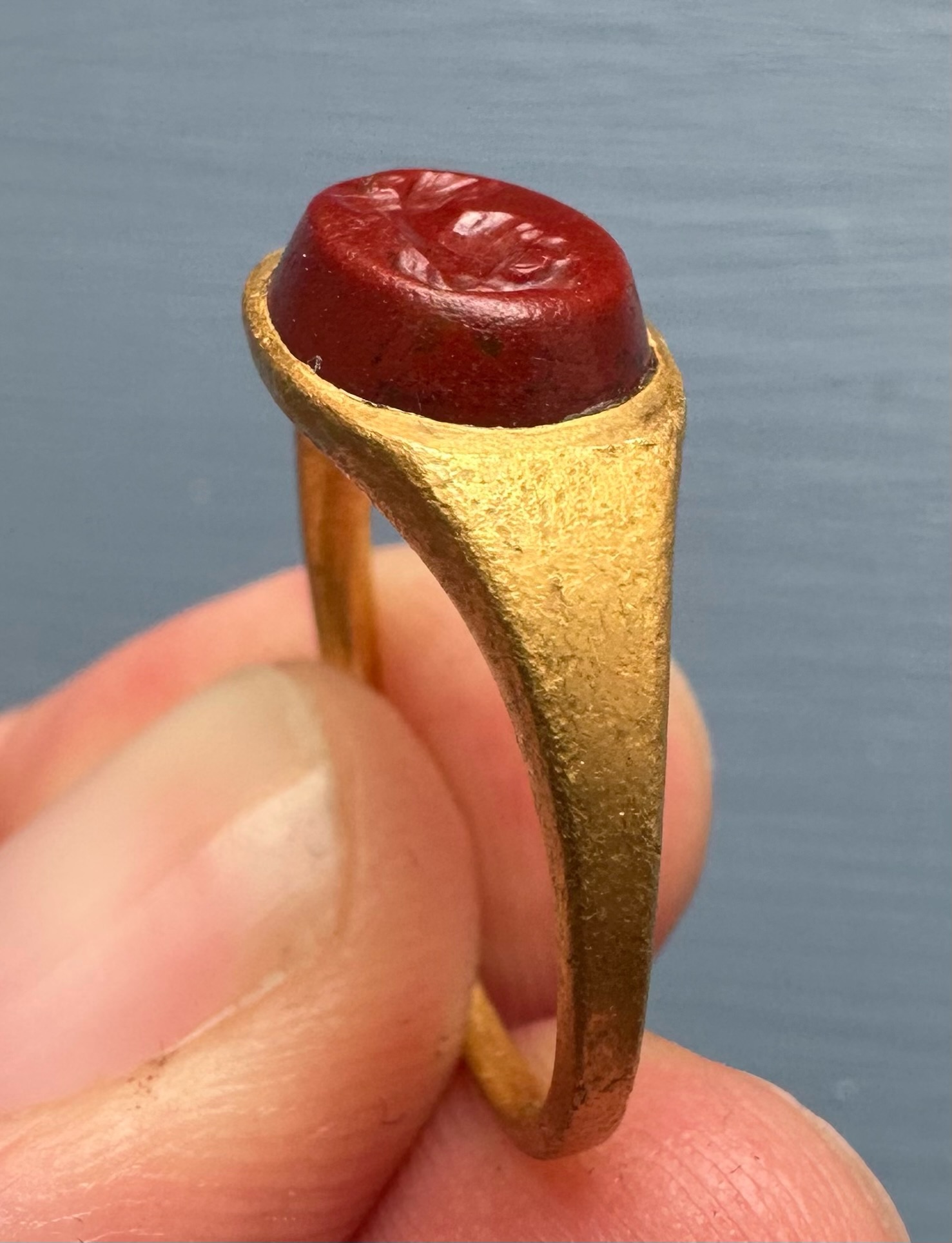 A Roman gold ring set with a red jasper intaglio. Bust of Mercury. 