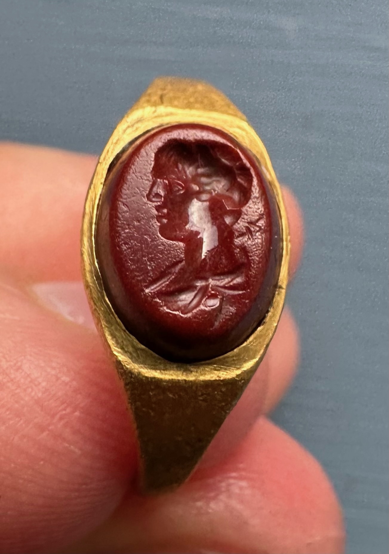 A Roman gold ring set with a red jasper intaglio. Bust of Mercury. 