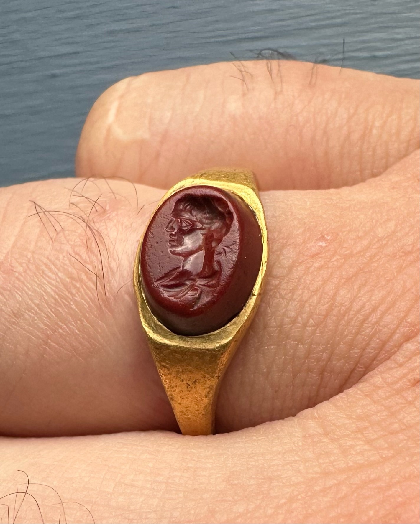 A Roman gold ring set with a red jasper intaglio. Bust of Mercury. 