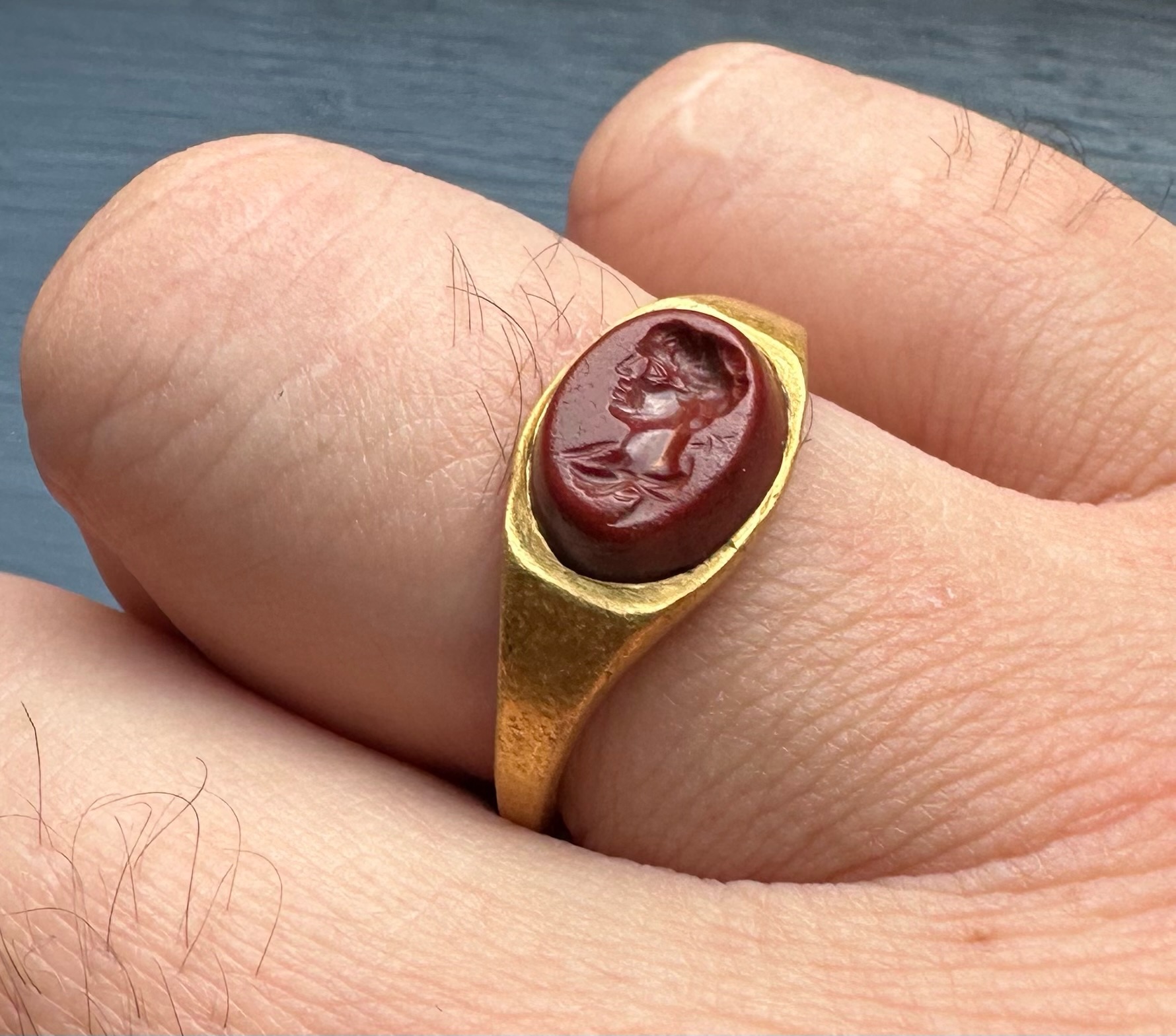 A Roman gold ring set with a red jasper intaglio. Bust of Mercury. 