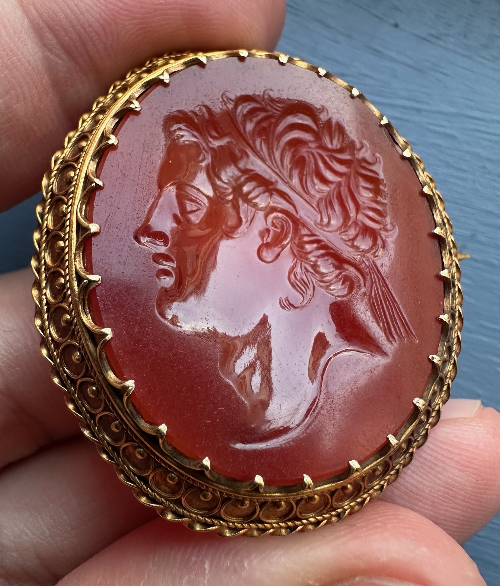 A 19th century gold brooch set with a large carnelian intaglio. Portrait of an Hellenistic ruler.