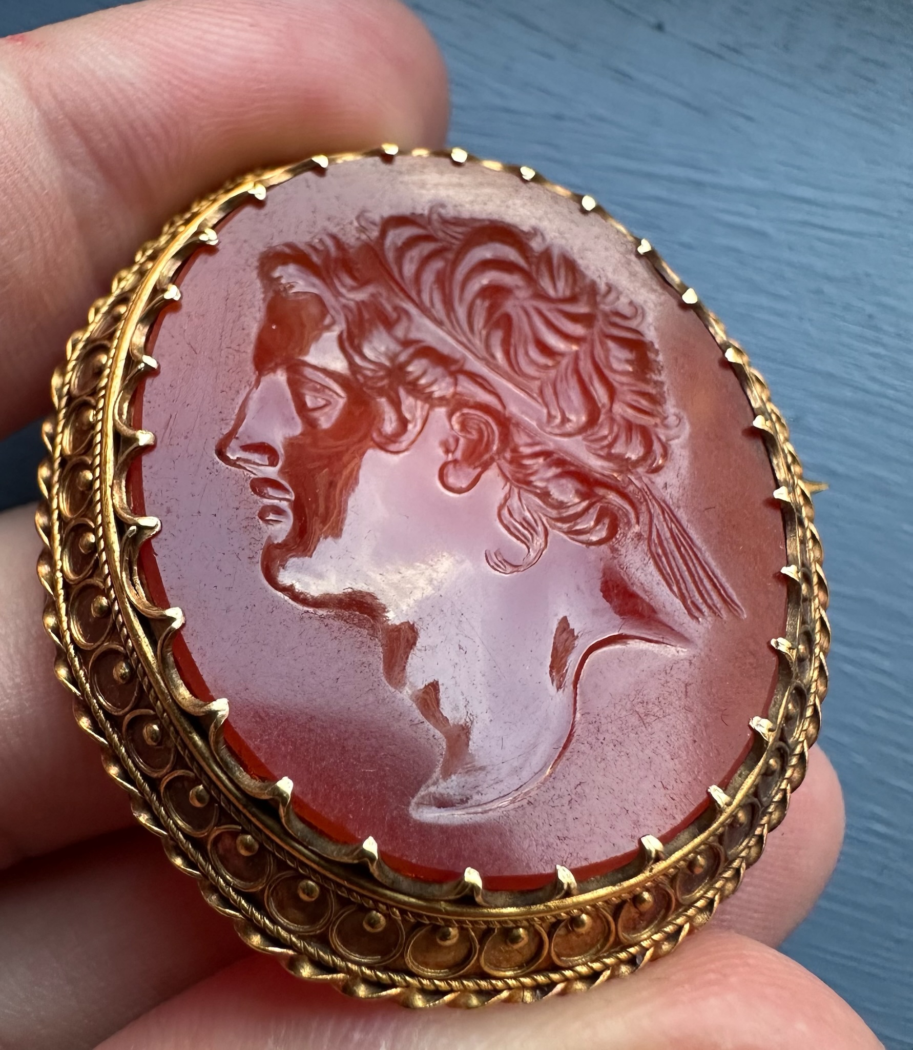 A 19th century gold brooch set with a large carnelian intaglio. Portrait of an Hellenistic ruler.