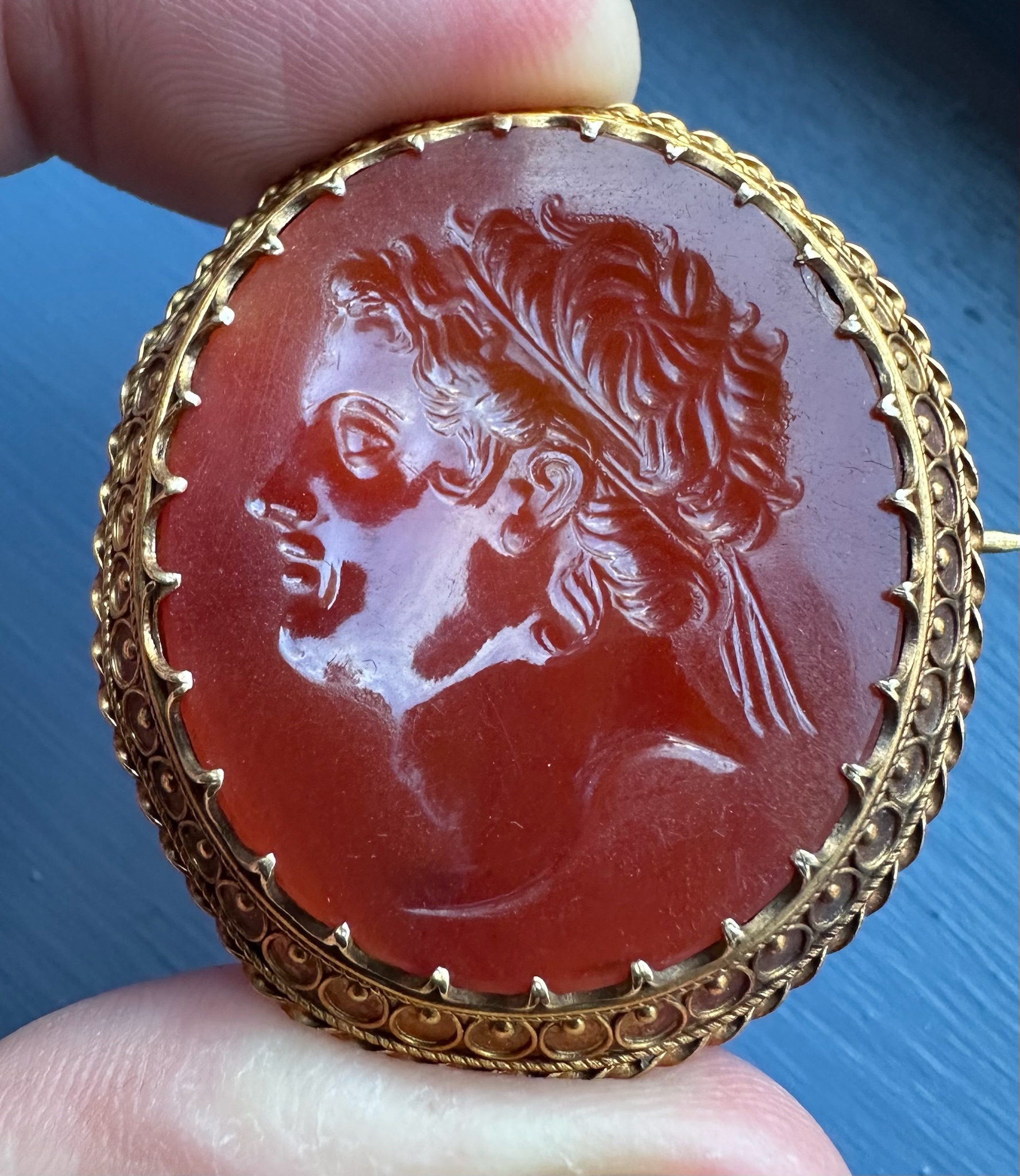 A 19th century gold brooch set with a large carnelian intaglio. Portrait of an Hellenistic ruler.