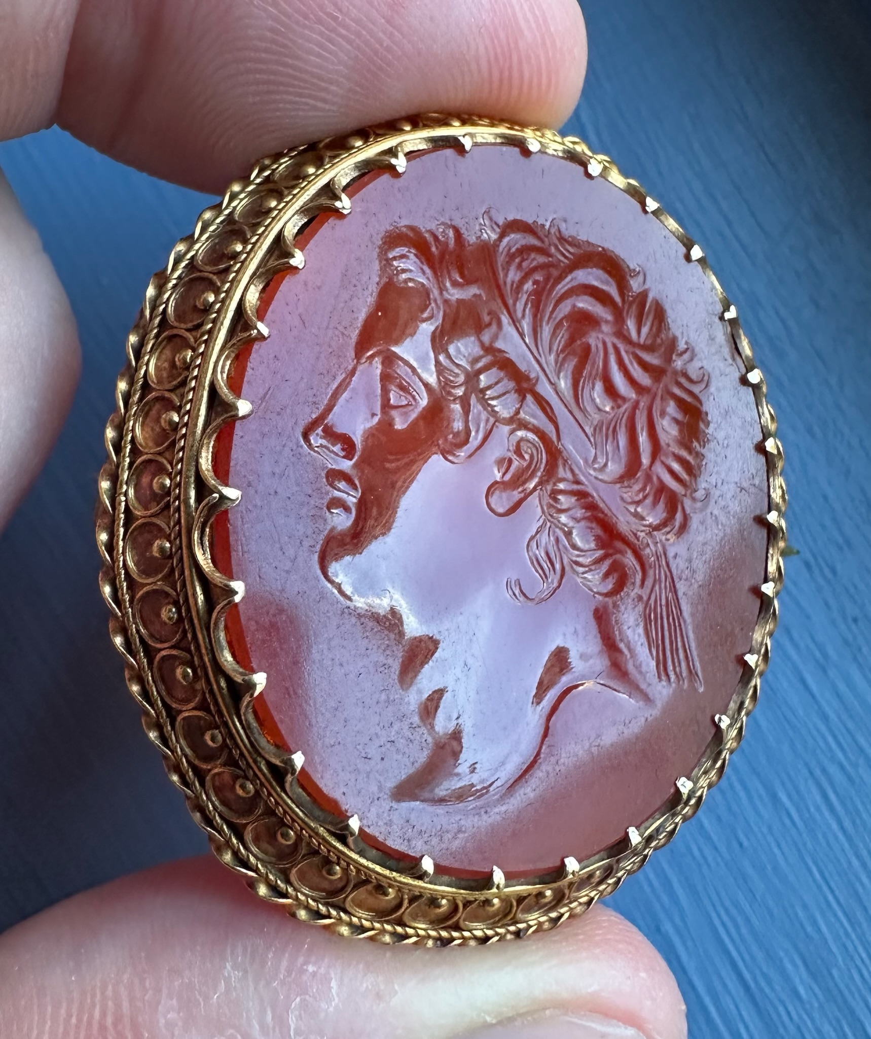 A 19th century gold brooch set with a large carnelian intaglio. Portrait of an Hellenistic ruler.