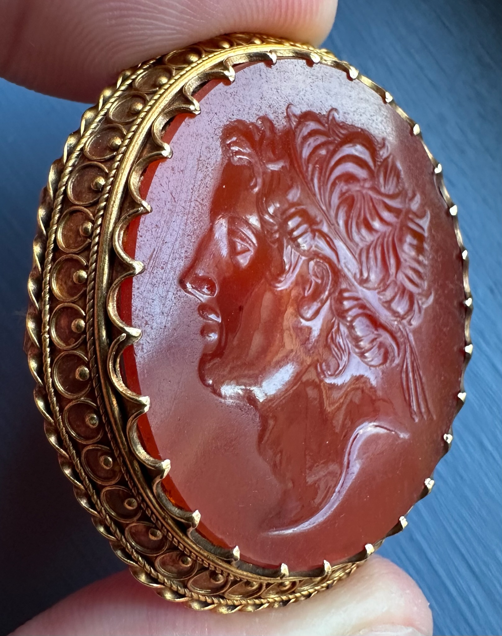 A 19th century gold brooch set with a large carnelian intaglio. Portrait of an Hellenistic ruler.