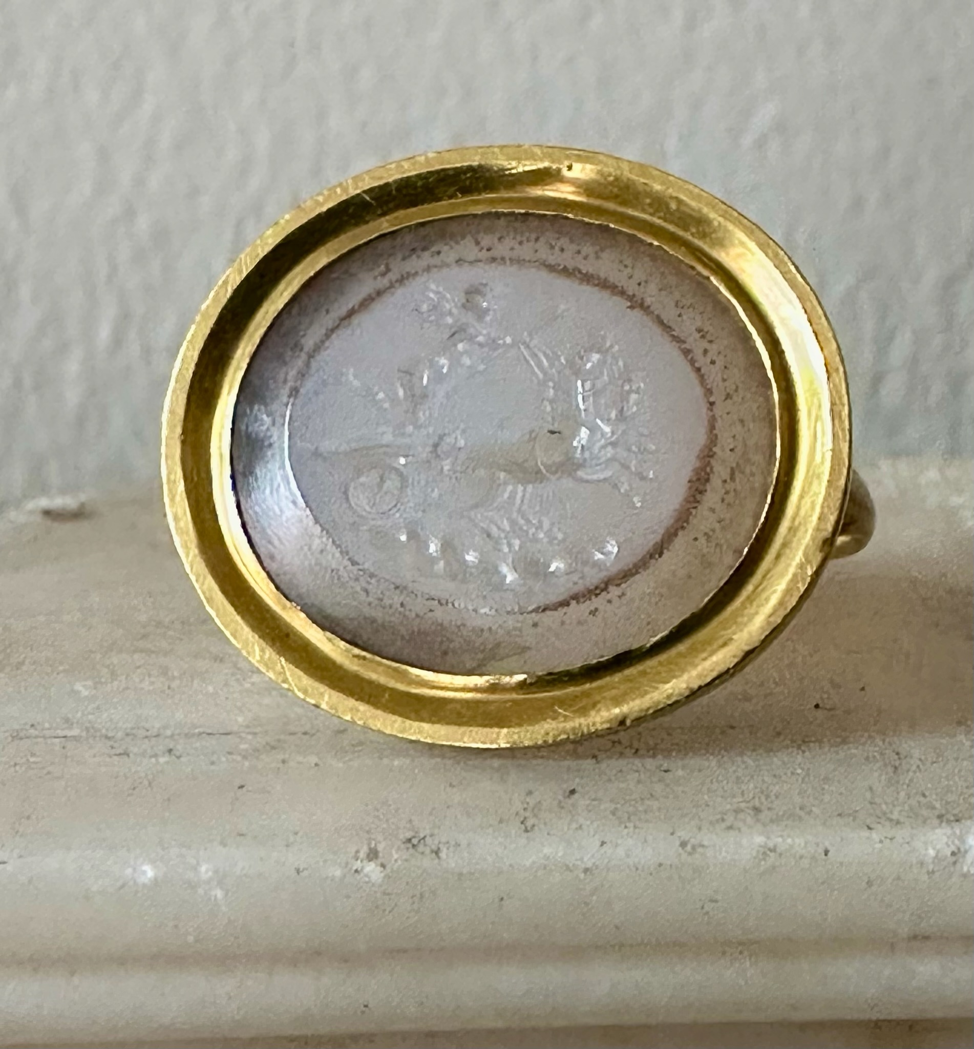 A Neoclassical chalcedony intaglio set in a 22k gold ring. The Conquest of Love.
