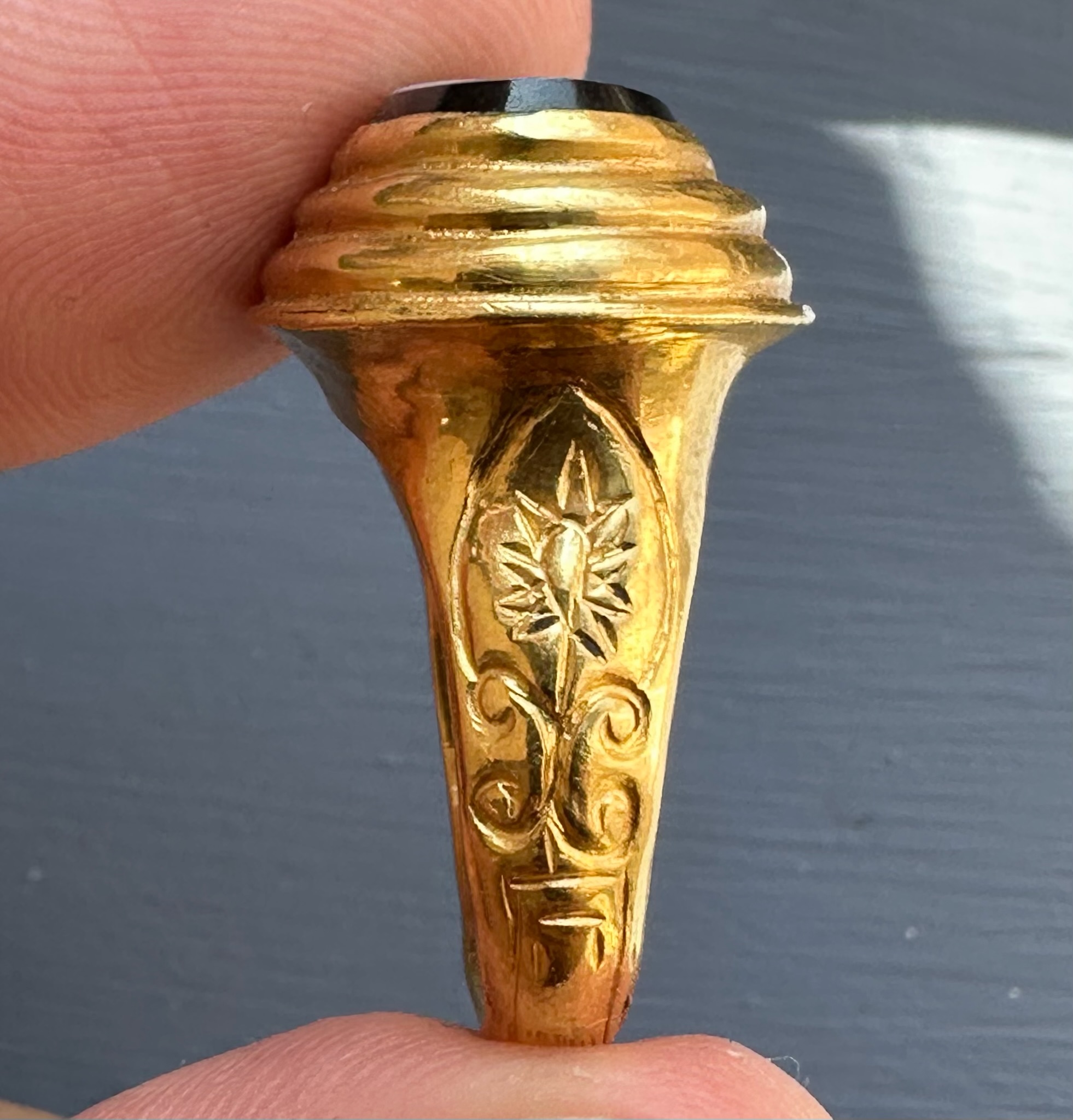 A 19th c. massive gold ring set with a nicolo intaglio. Veiled Juno. 