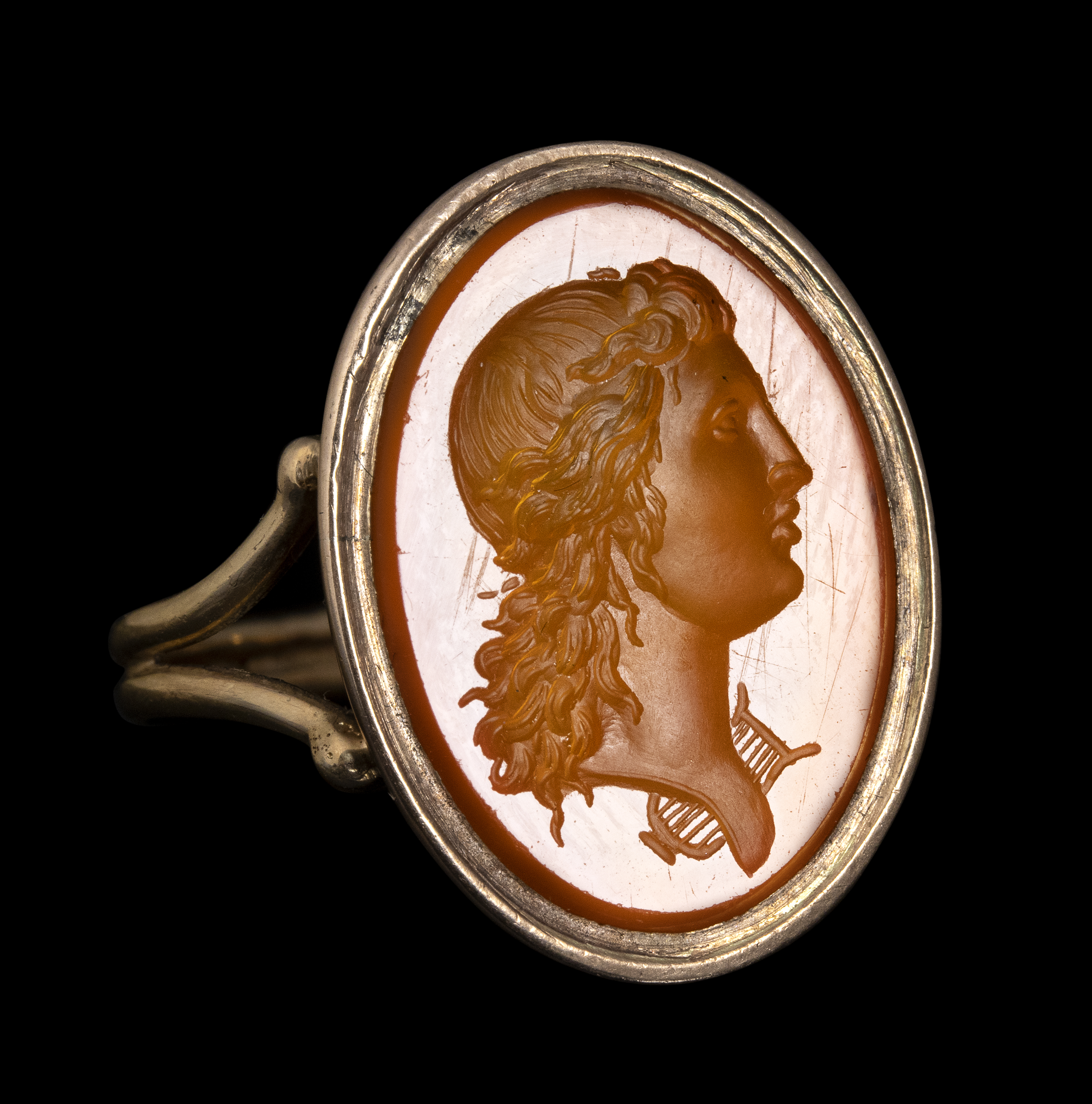 Neoclassical, A 19th century gold ring set with a Neoclassical carnelian intaglio. Bust of Apollo.  (19th century)
