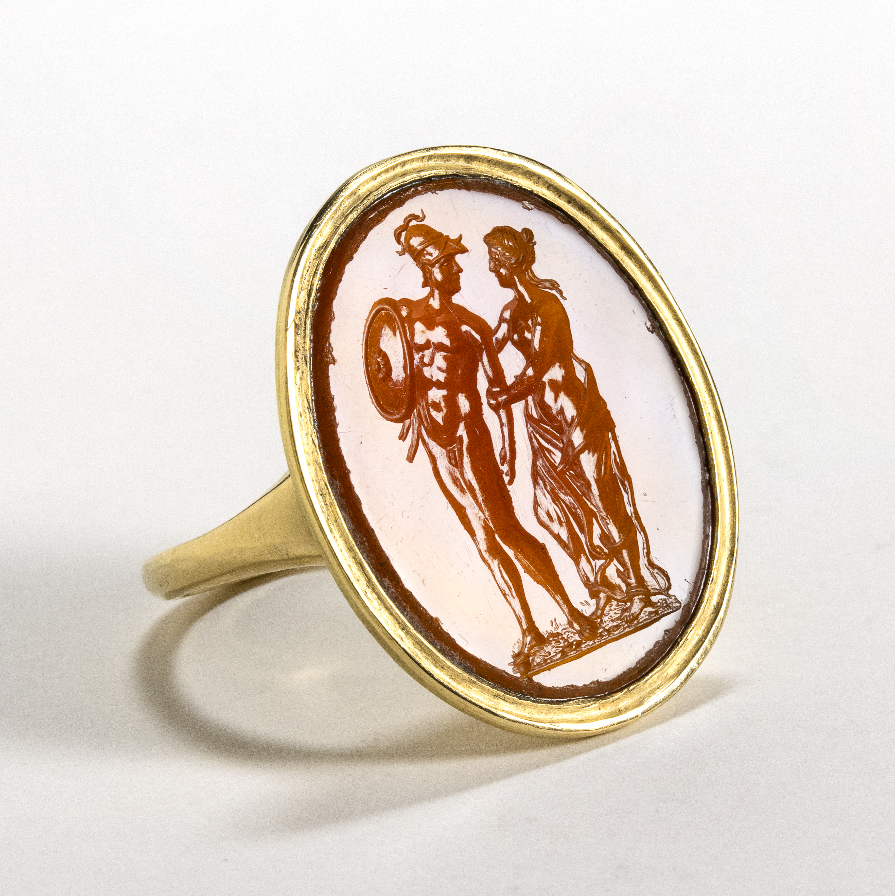 A Large Neoclassical carnelian intaglio set in a later massive gold ring. Mars and Venus.