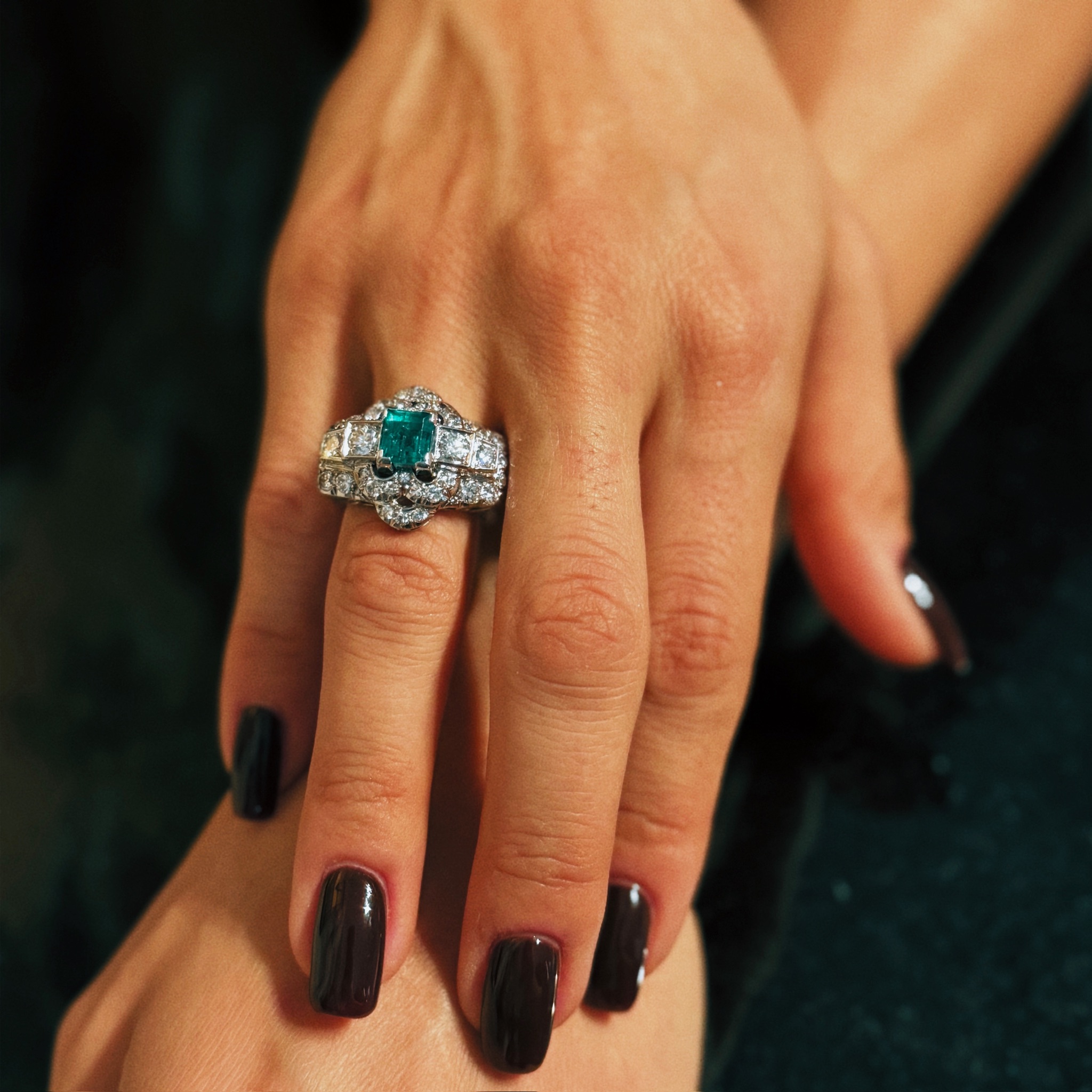 A diamond and platinum ring, set with a rectangular shaped emerald (ca. 1960)