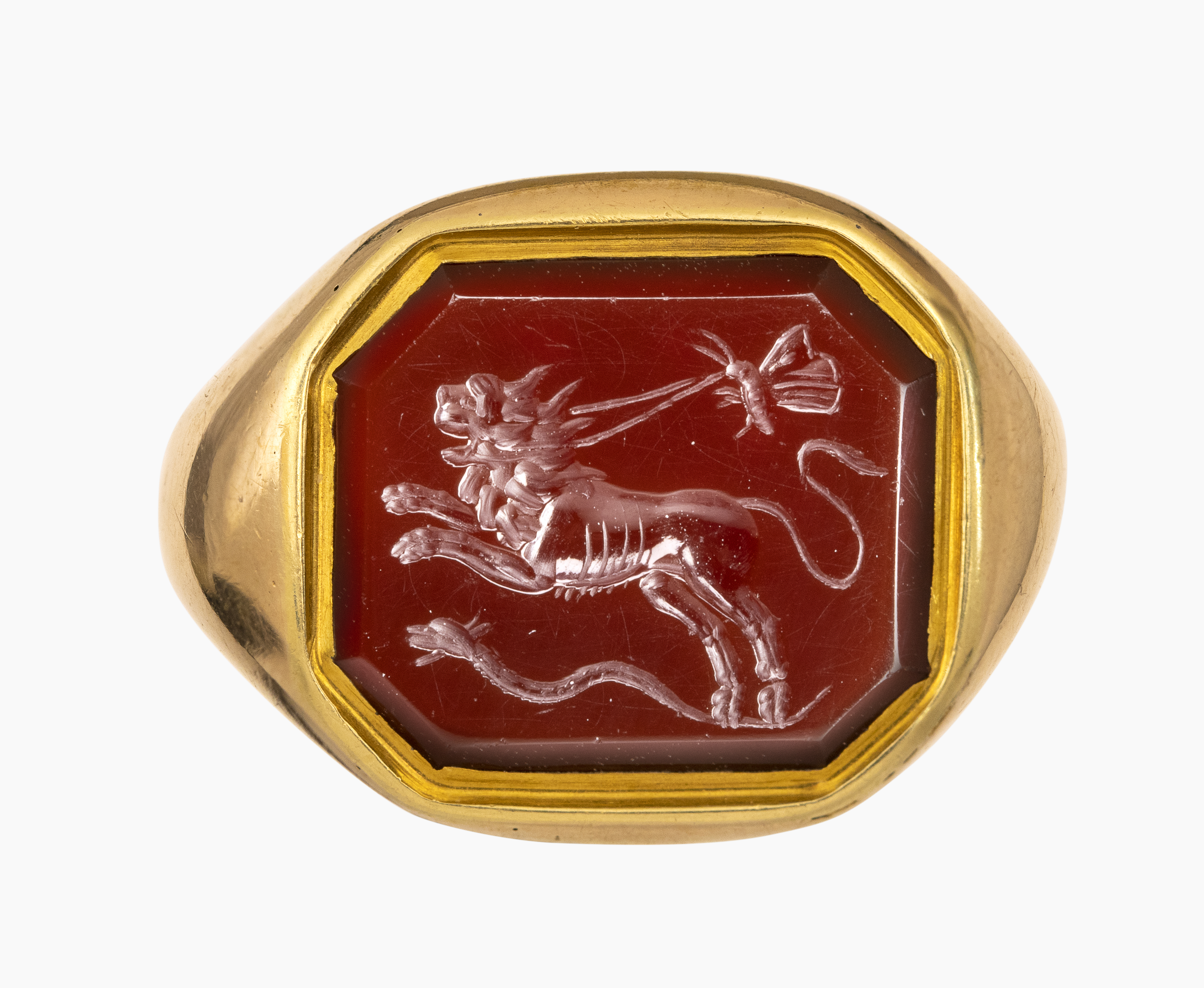 Roman, Late 19th century, A 19th century gold ring set with a Roman carnelian intaglio. Allegorical scene with lion.  (1st-2nd century A.D. )