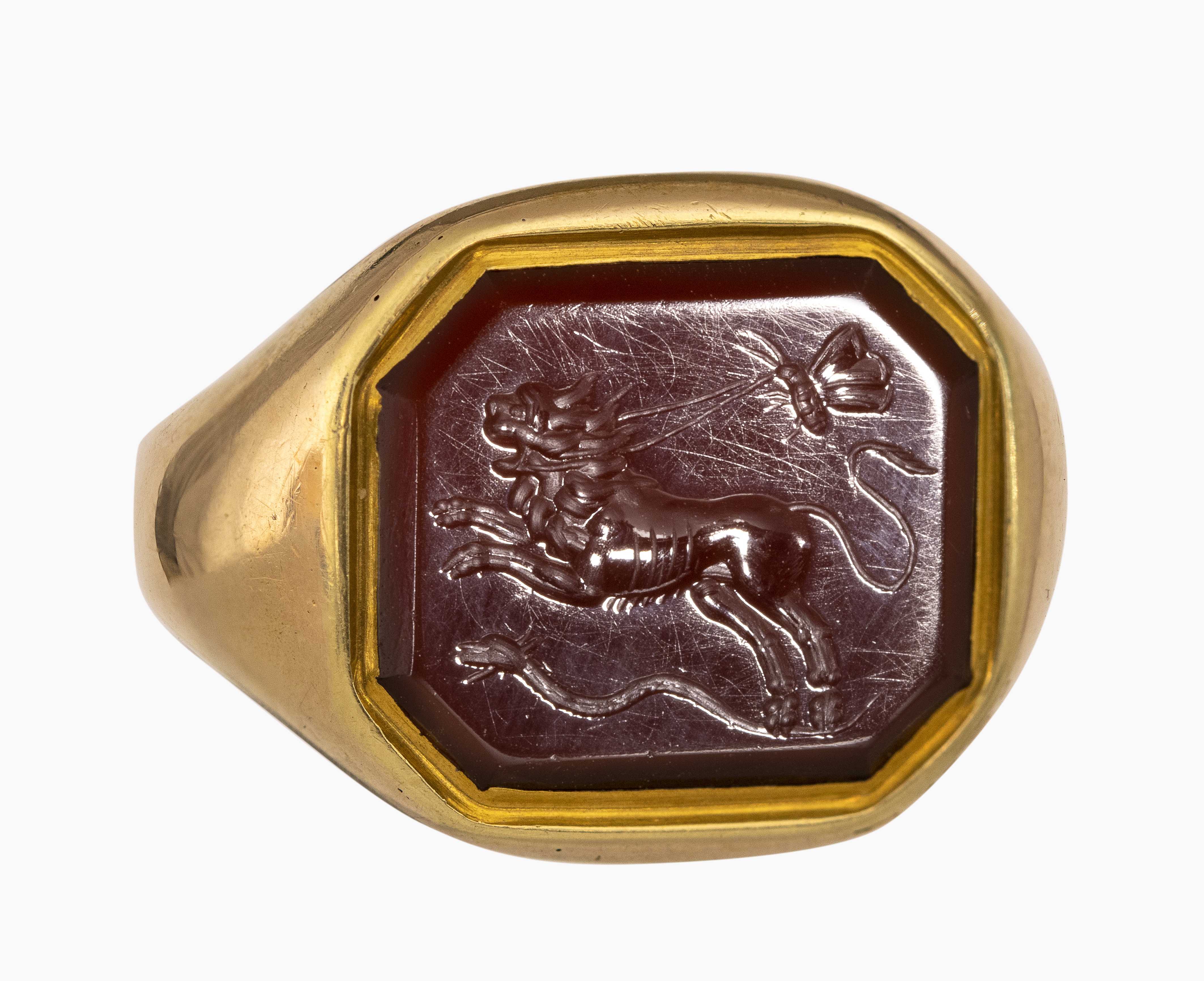 Roman, Late 19th century, A 19th century gold ring set with a Roman carnelian intaglio. Allegorical scene with lion.  (1st-2nd century A.D. )