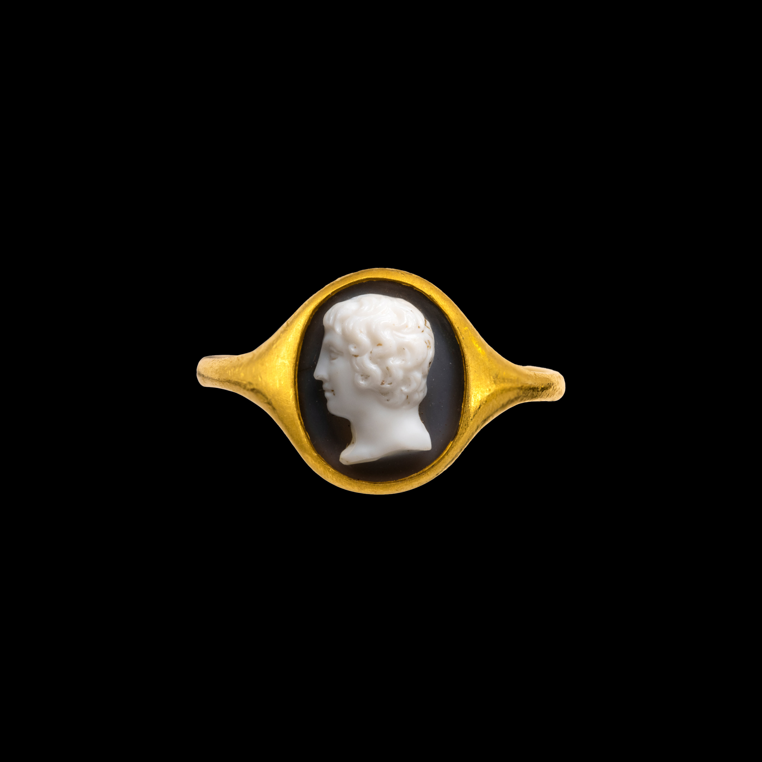 A high carat gold ring set with a Neoclassical onyx cameo. Portrait of a Youth.  (19th century)