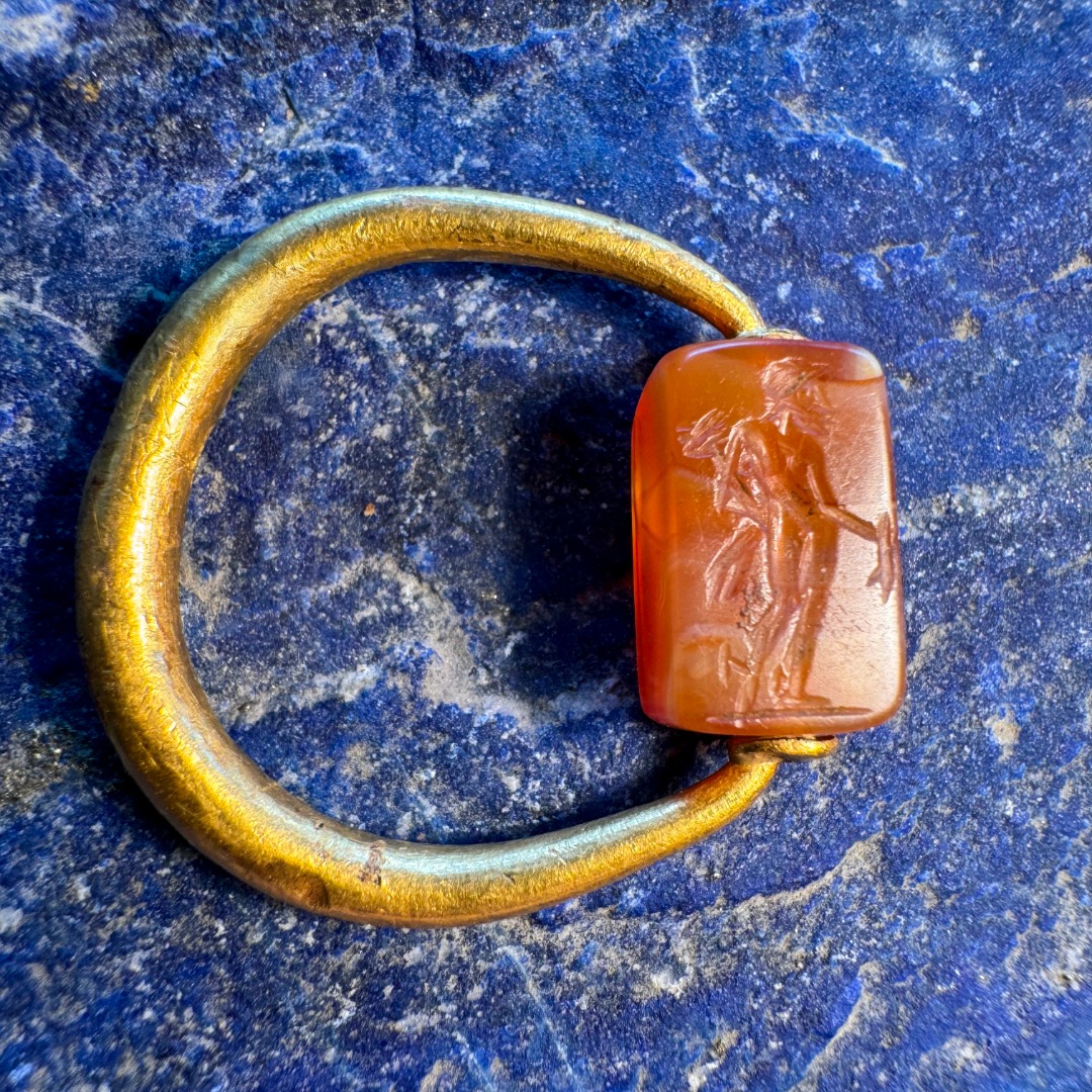 A Graeco-Persian gold swivel ring with a carnelian engraved seal. Mercury and male figure.