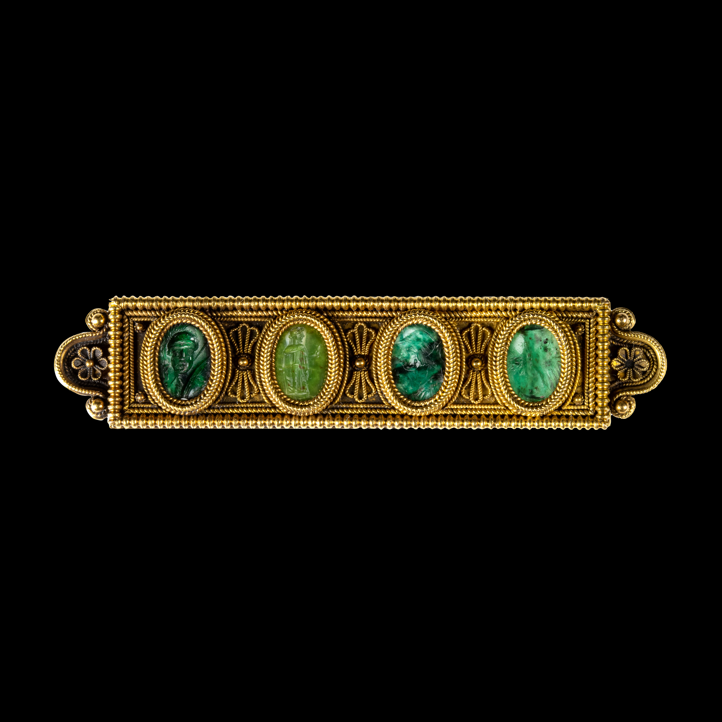 An Etruscan Revival gold brooch set with Roman green chalcedony intaglios.