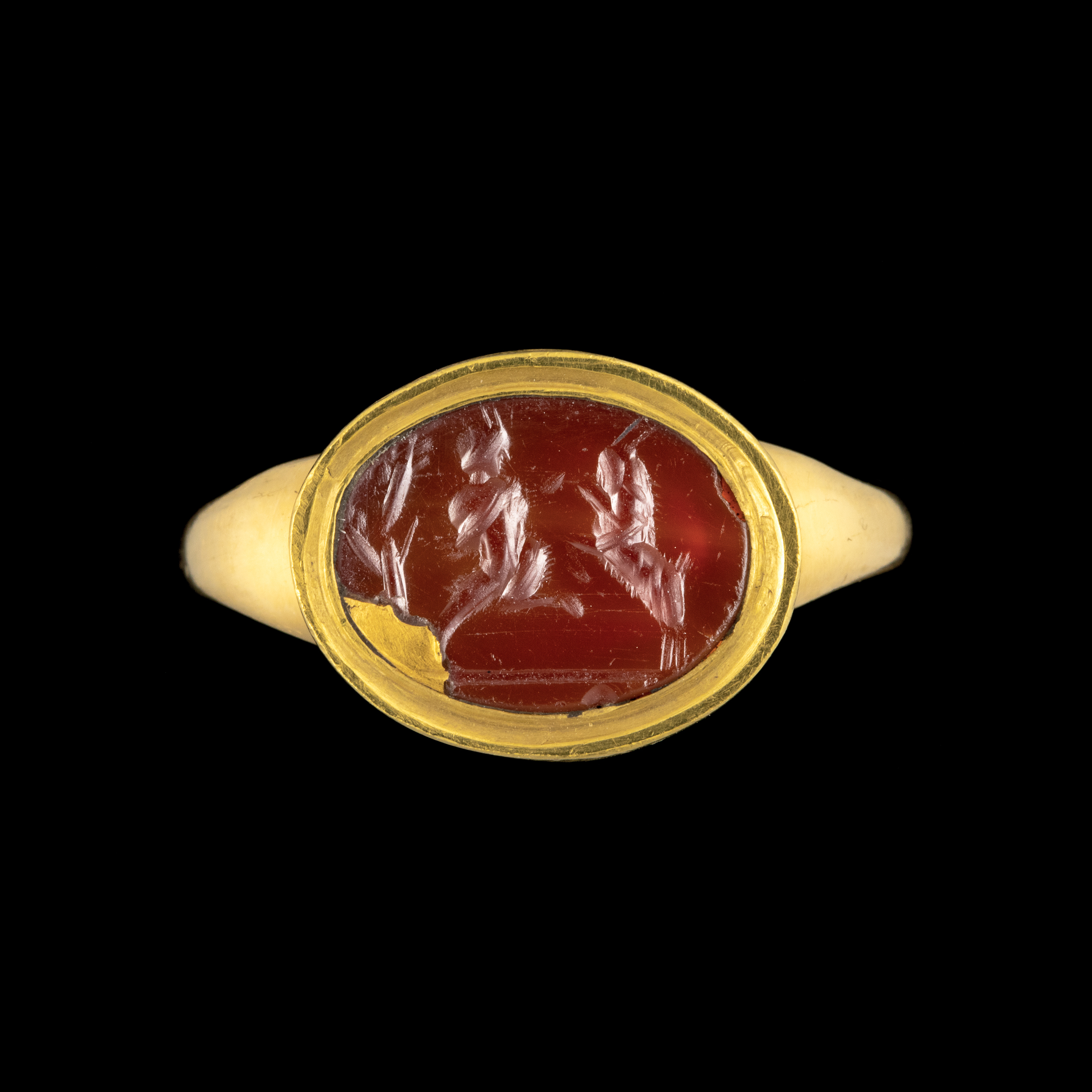 A gold ring set with a Roman carnelian intaglio. Pan fighting a goat.